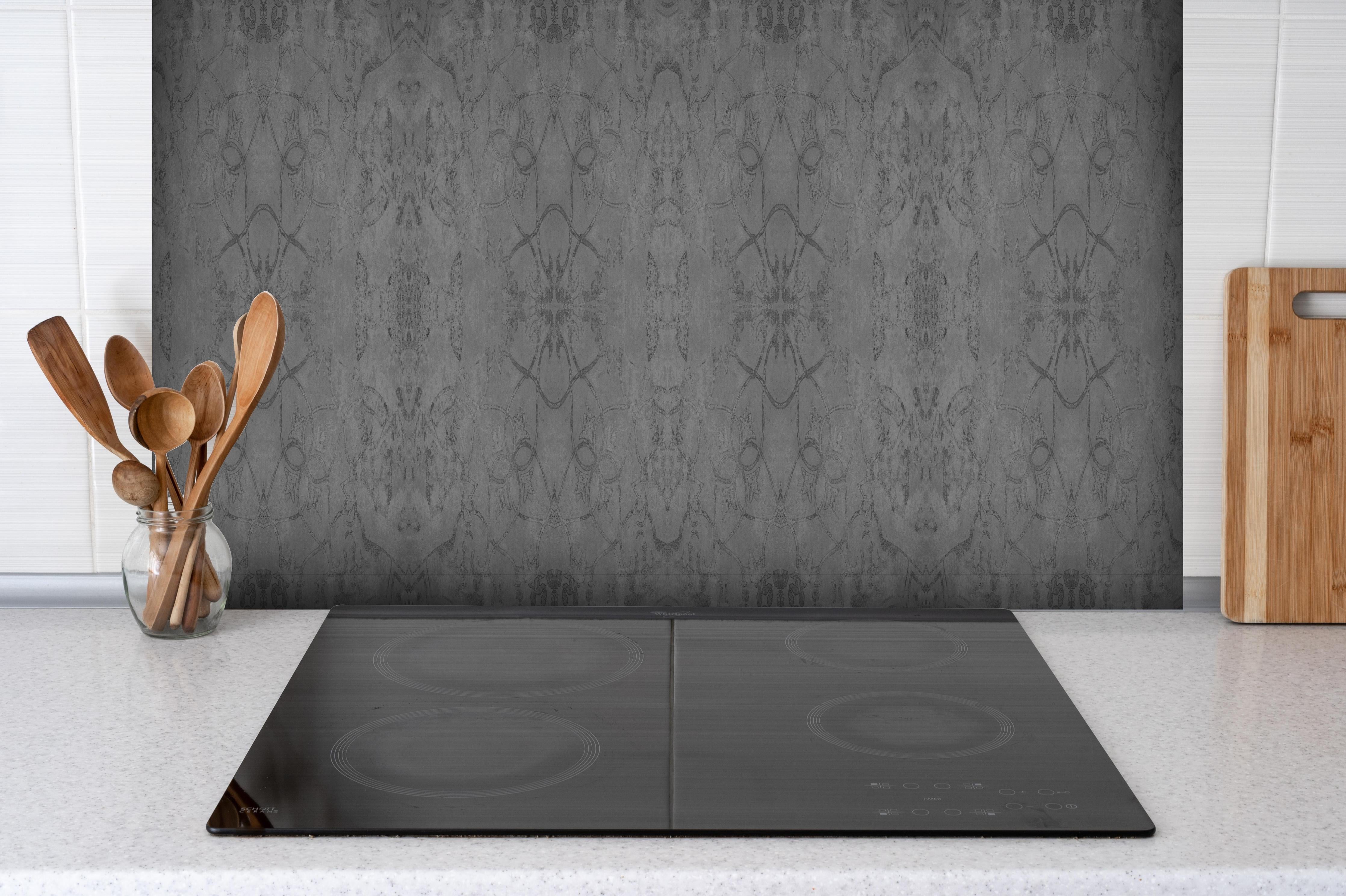 Spritzschutz - Altes anthrazitgraues Vintage Muster hinter einem Cerankochfeld zwischen Holz-Kochutensilien