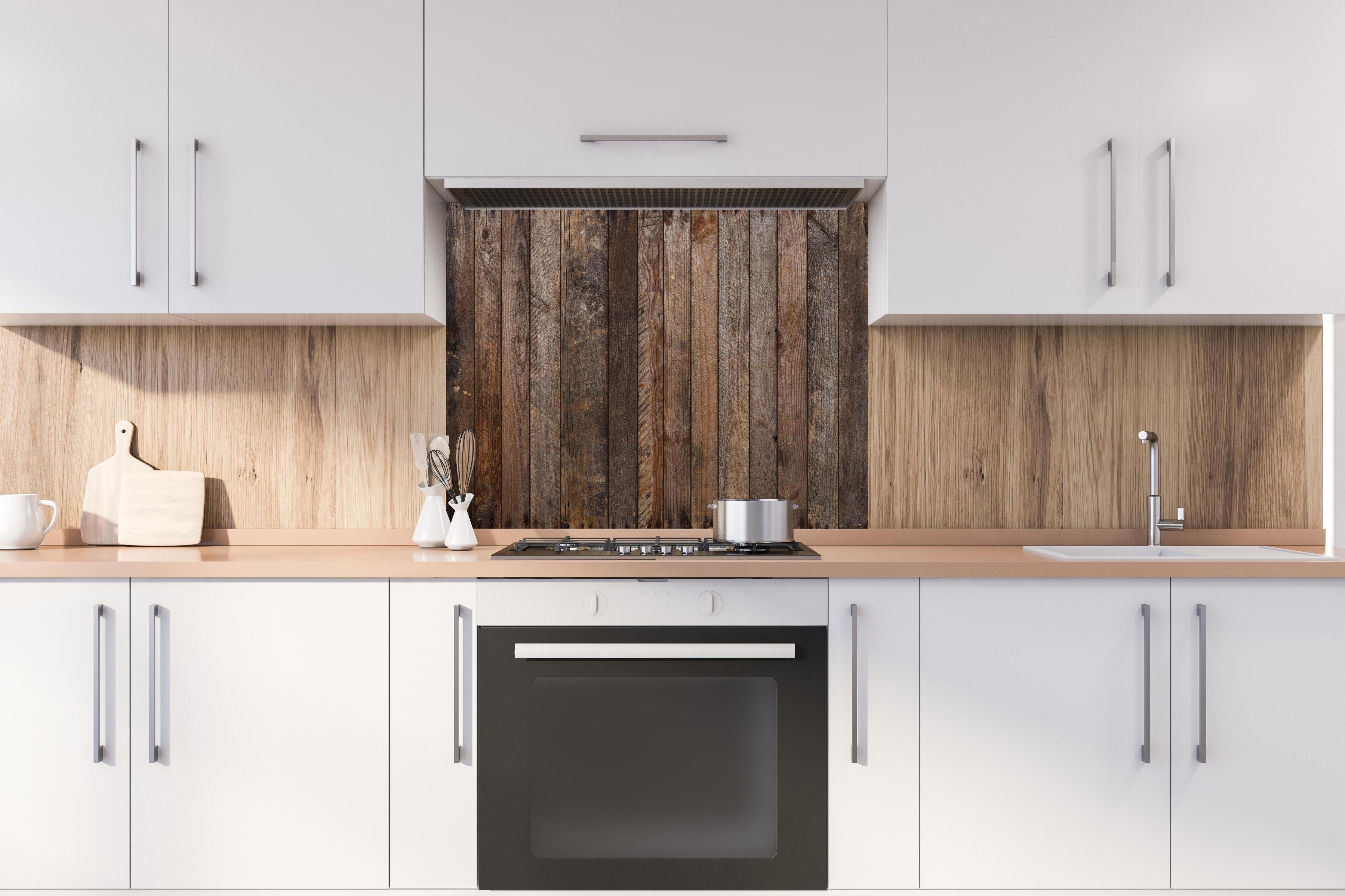 Spritzschutz - Altes verwittertes Plankenholz mit Rostnägeln hinter einem Cerankochfeld zwischen Holz-Kochutensilien