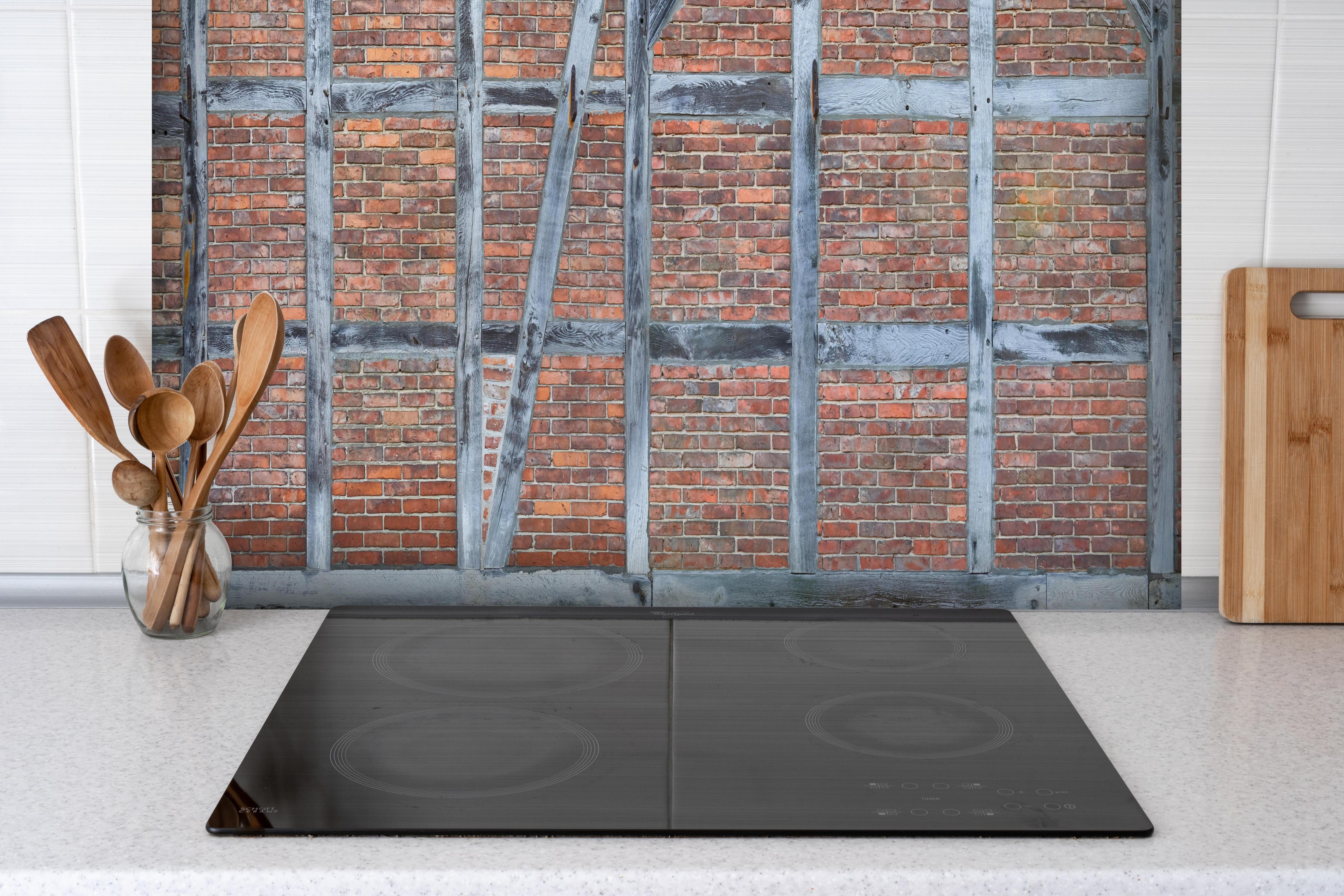 Spritzschutz - Altmodische Wand aus Niedersachen hinter einem Cerankochfeld zwischen Holz-Kochutensilien