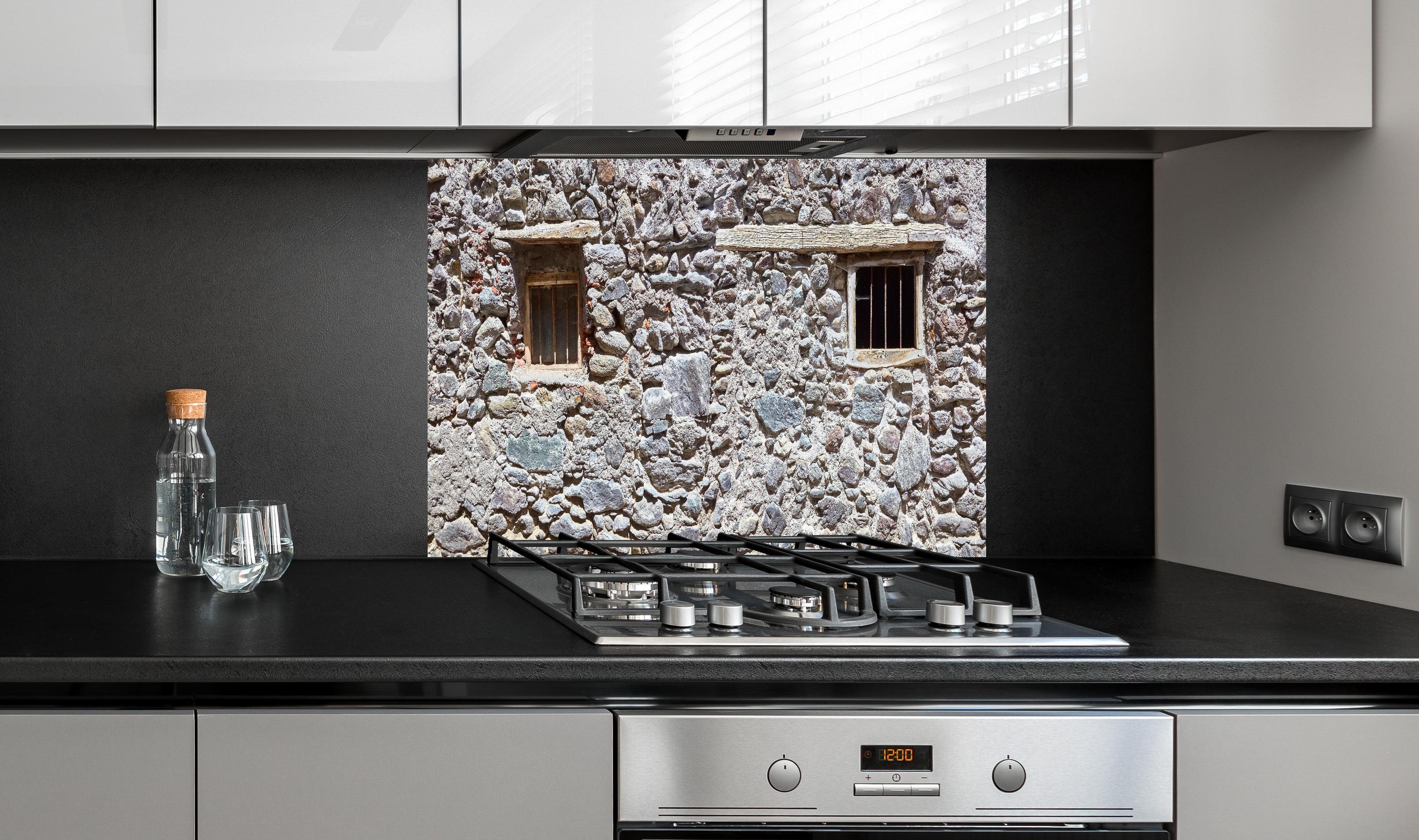 Spritzschutz - Altmodischer Kuhstall hinter einem Cerankochfeld zwischen Holz-Kochutensilien