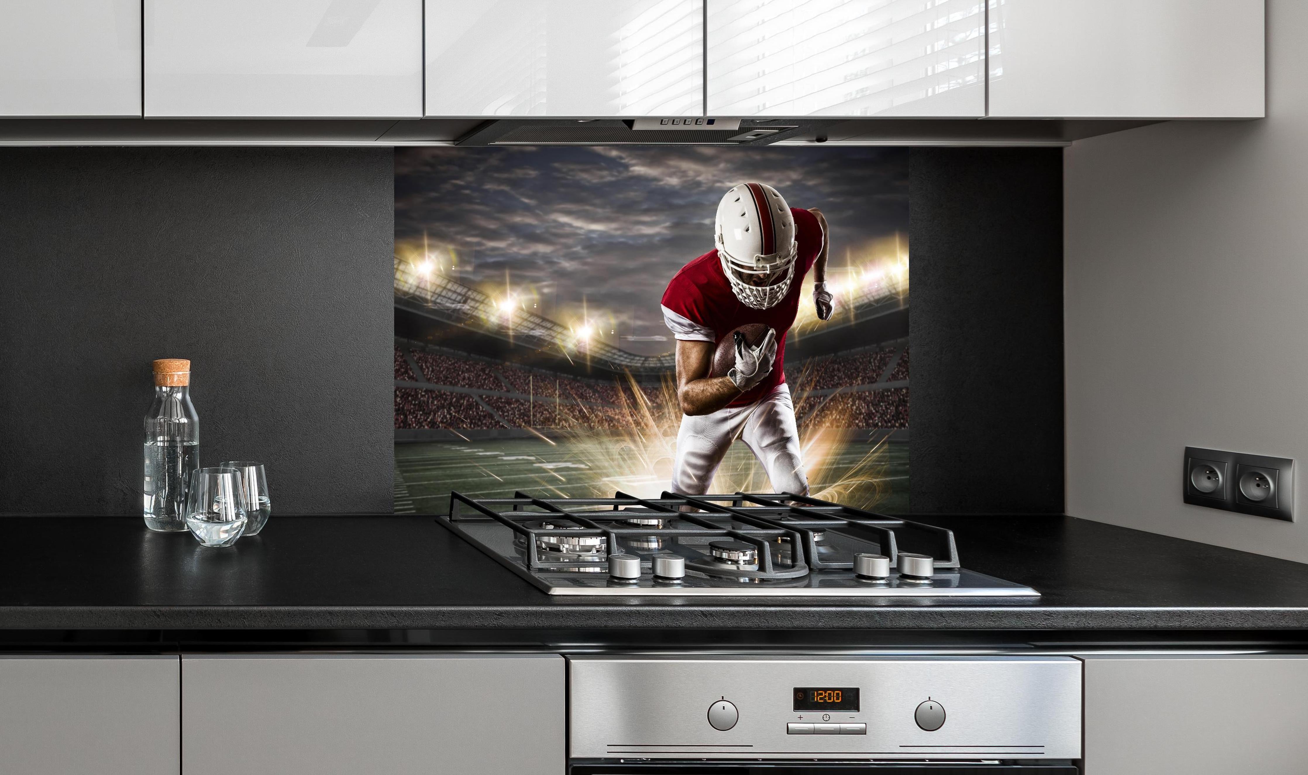 Spritzschutz - American Fußballspieler hinter einem Cerankochfeld zwischen Holz-Kochutensilien