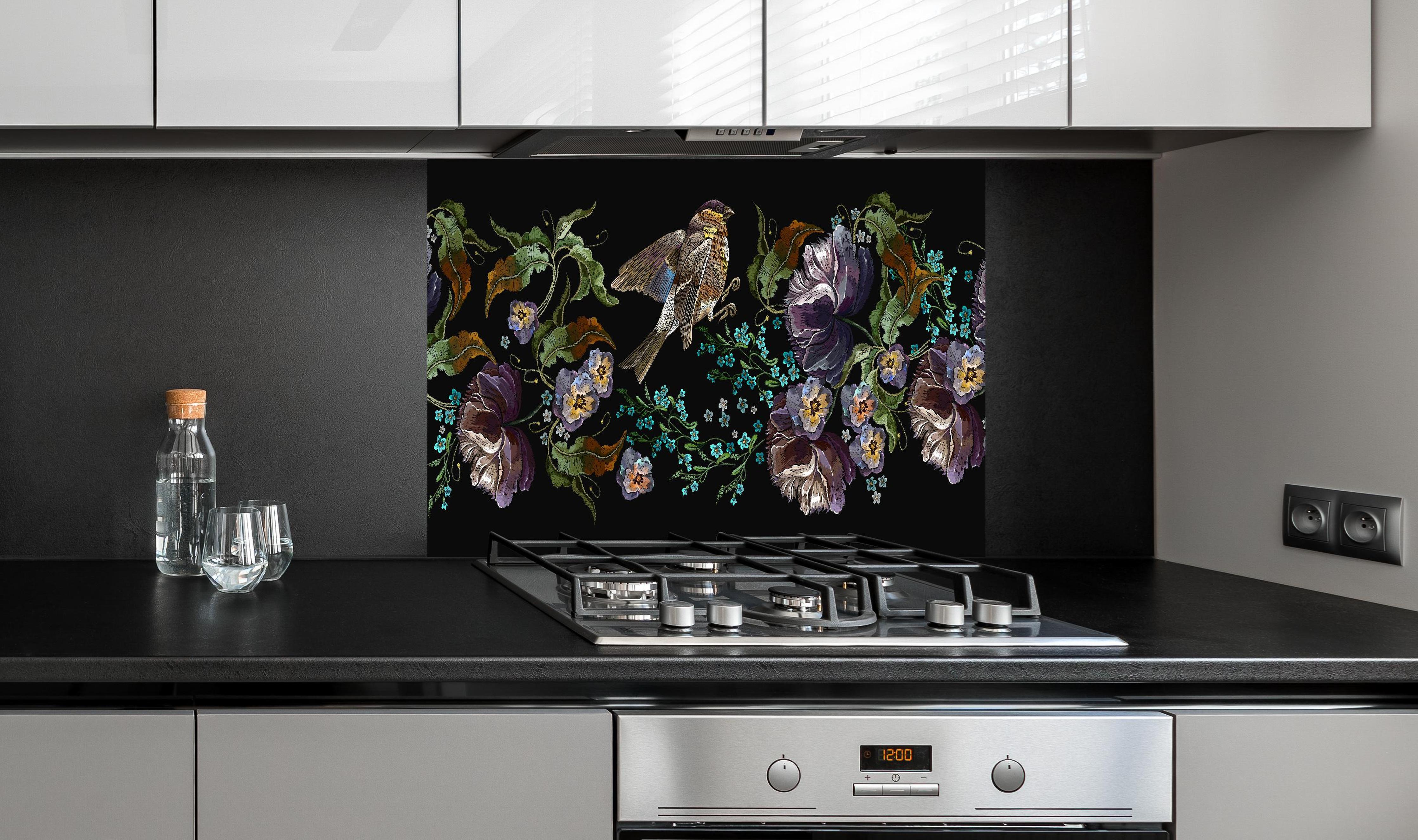 Spritzschutz - Amsel bei Nacht - Stickmuster hinter einem Cerankochfeld zwischen Holz-Kochutensilien