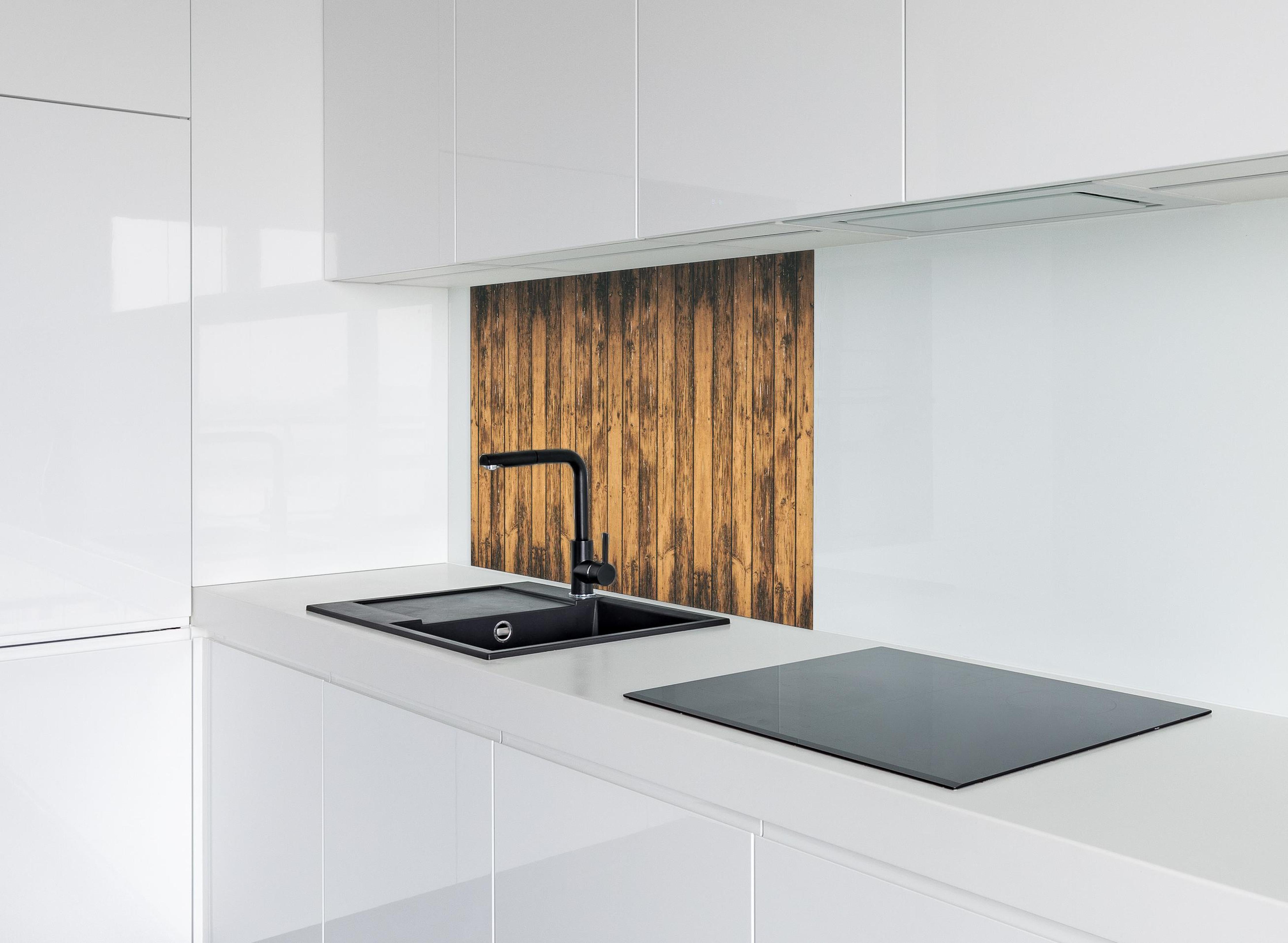 Spritzschutz - Aneinandergereihte leicht angebrannte Holzplatten hinter einem Cerankochfeld zwischen Holz-Kochutensilien