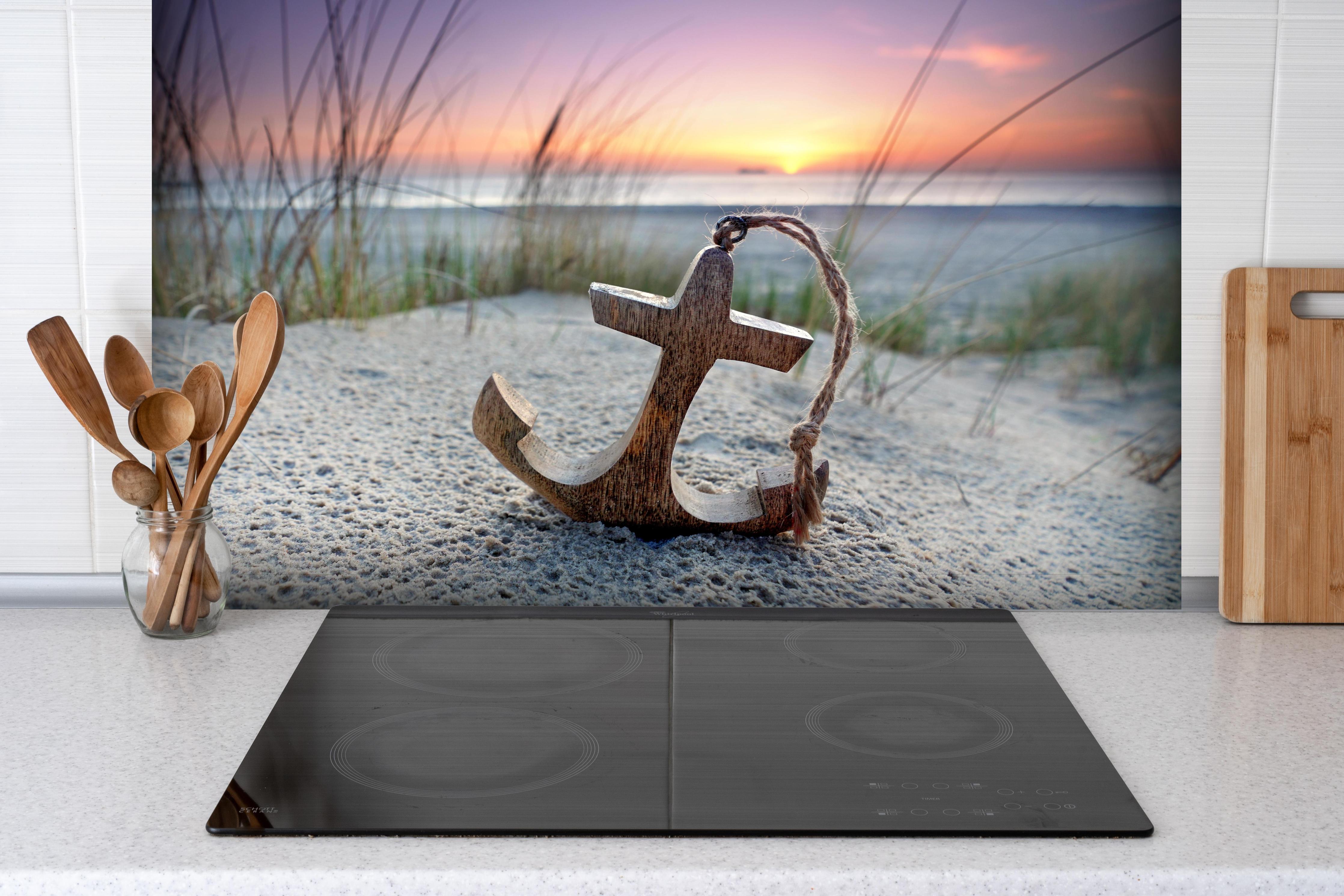 Spritzschutz - Anker am Strand hinter einem Cerankochfeld zwischen Holz-Kochutensilien