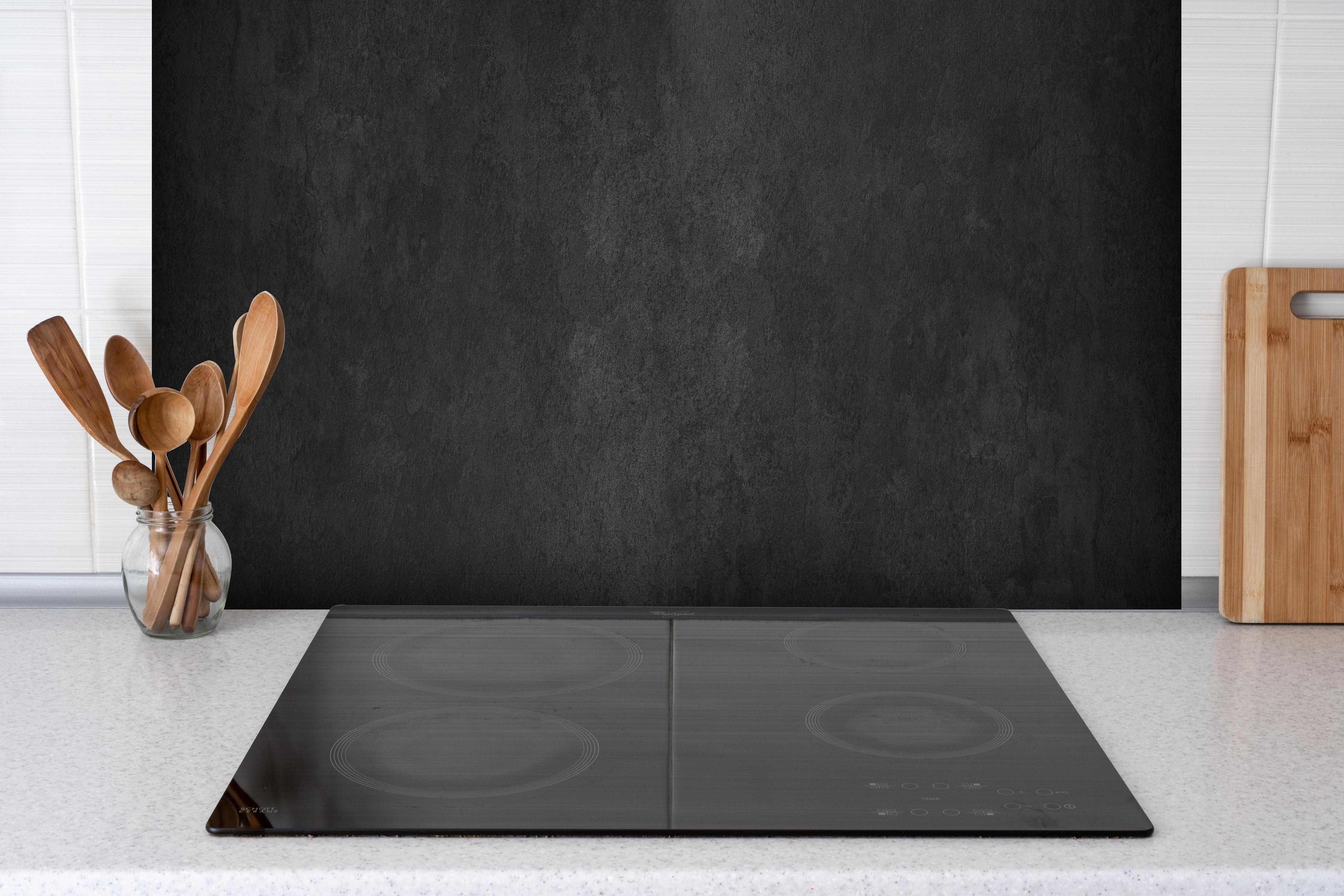 Spritzschutz - Anthrazit Betonstruktur hinter einem Cerankochfeld zwischen Holz-Kochutensilien