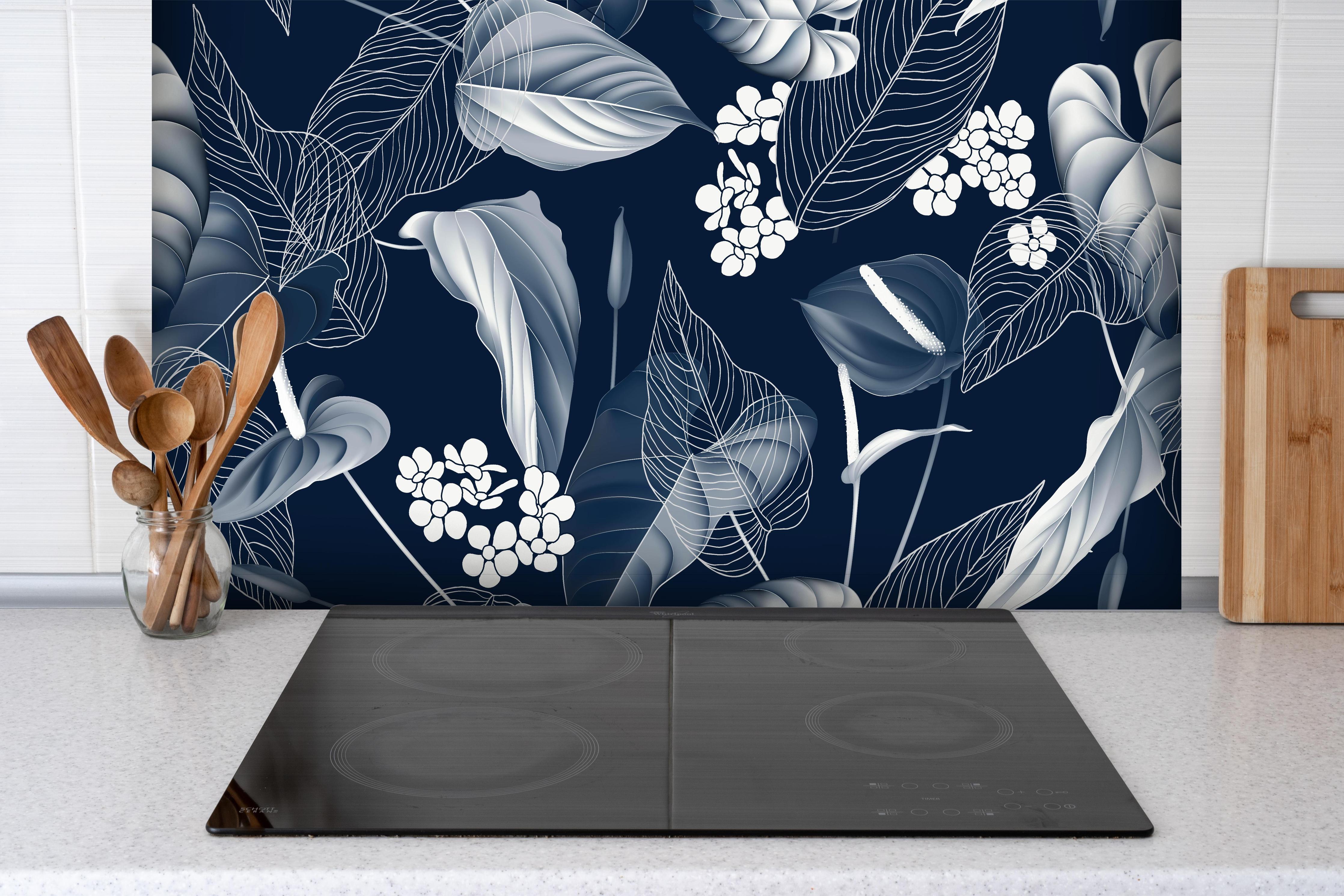 Spritzschutz - Anthurium Blumenmuster Blautöne auf Dunkelblau hinter einem Cerankochfeld zwischen Holz-Kochutensilien