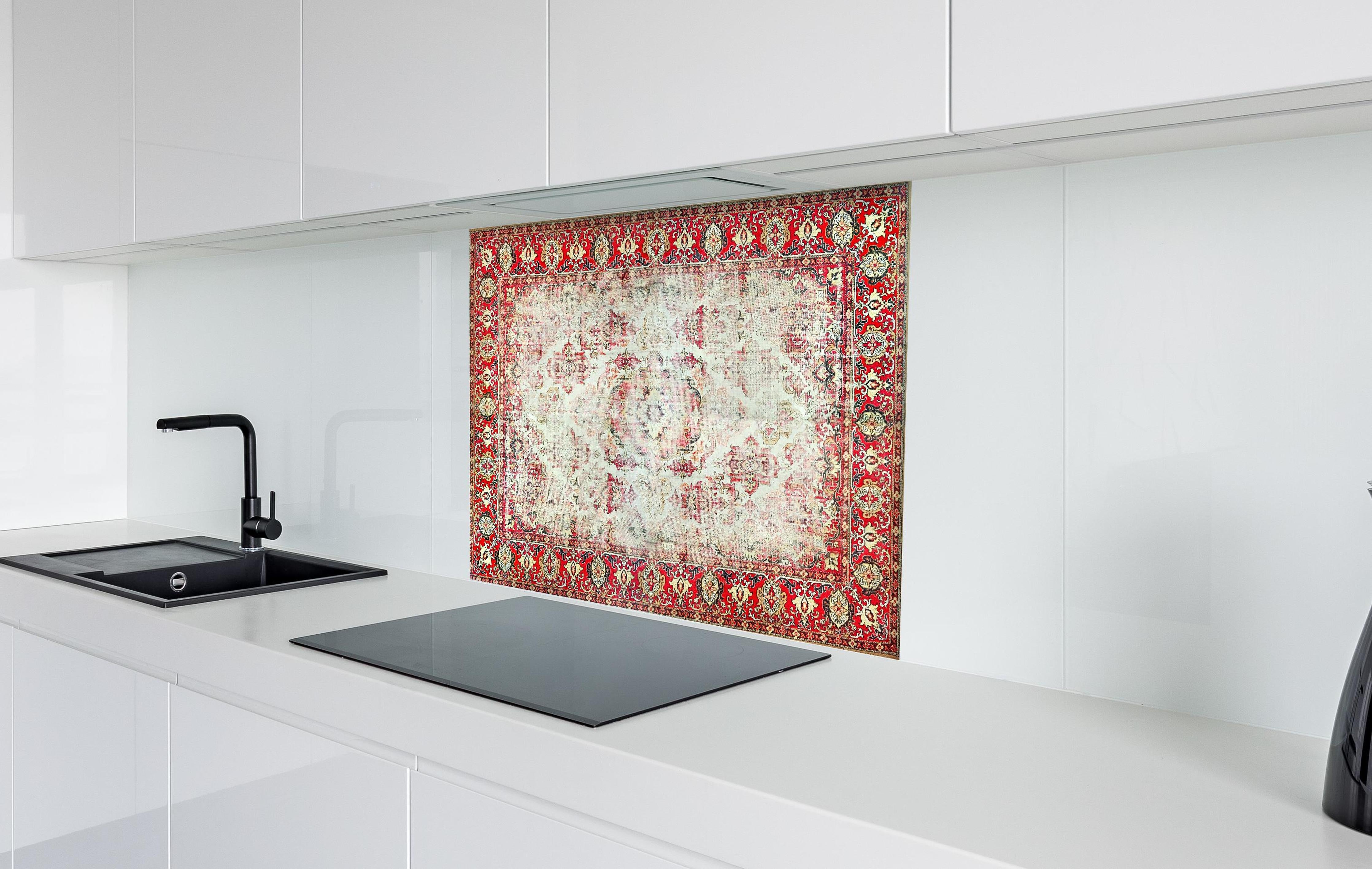 Spritzschutz - Antiker Rot-Beige-Wollteppich mit Muster hinter einem Cerankochfeld zwischen Holz-Kochutensilien