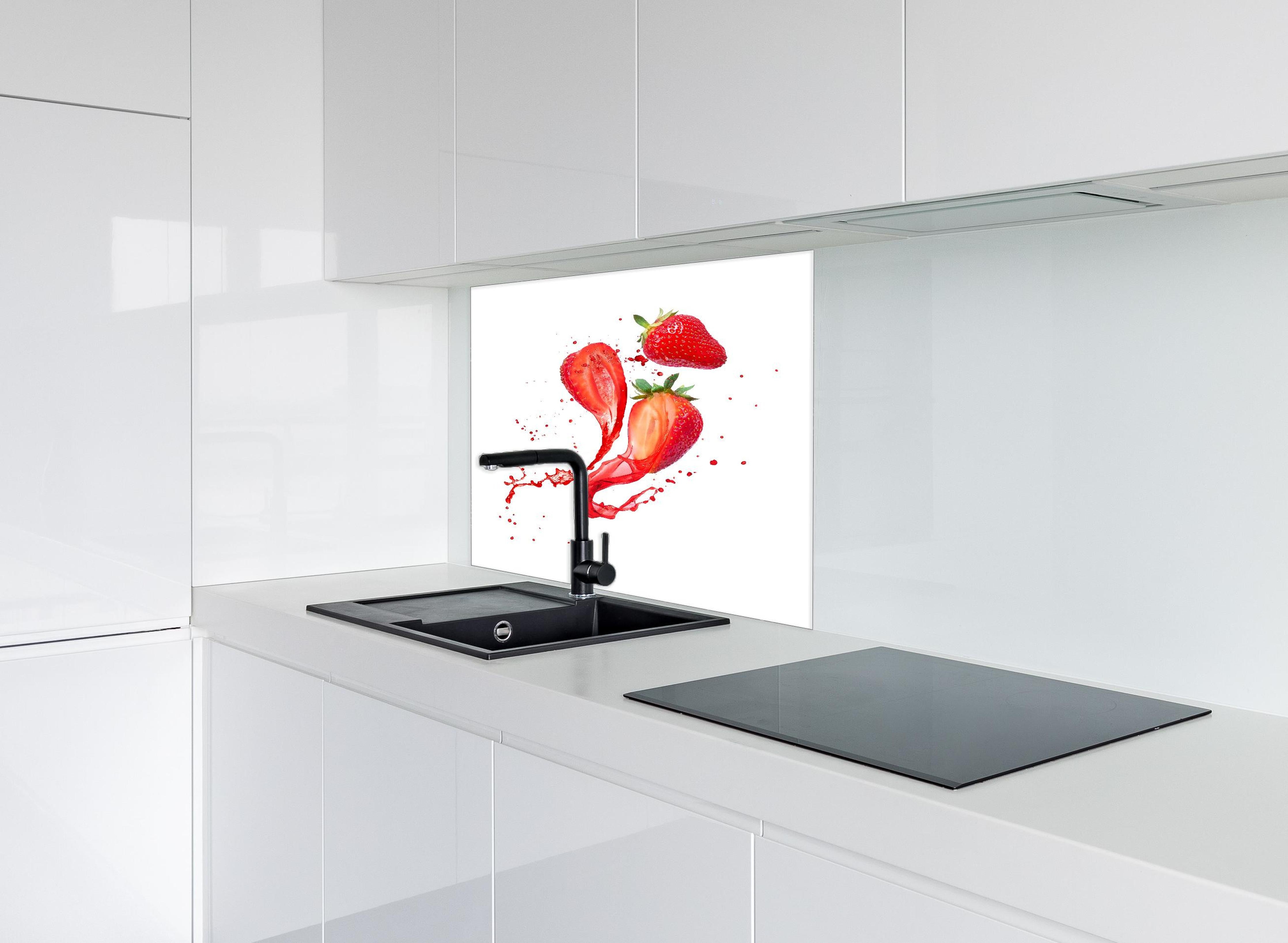 Spritzschutz - Aufgeschnittene Erdbeeren auf weißem Hintergrund hinter einem Cerankochfeld zwischen Holz-Kochutensilien