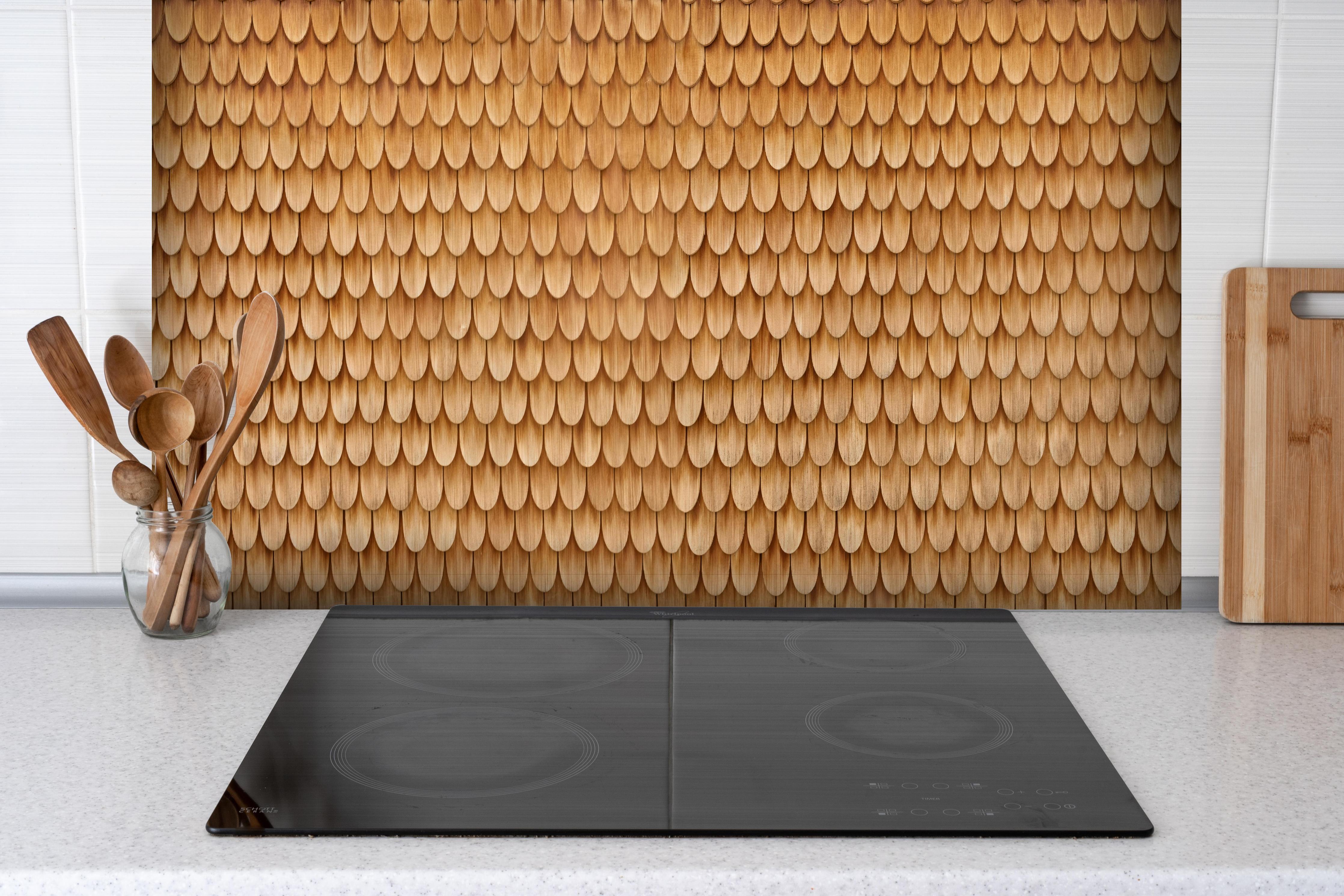 Spritzschutz - Bayrische Holzschindeln hinter einem Cerankochfeld zwischen Holz-Kochutensilien