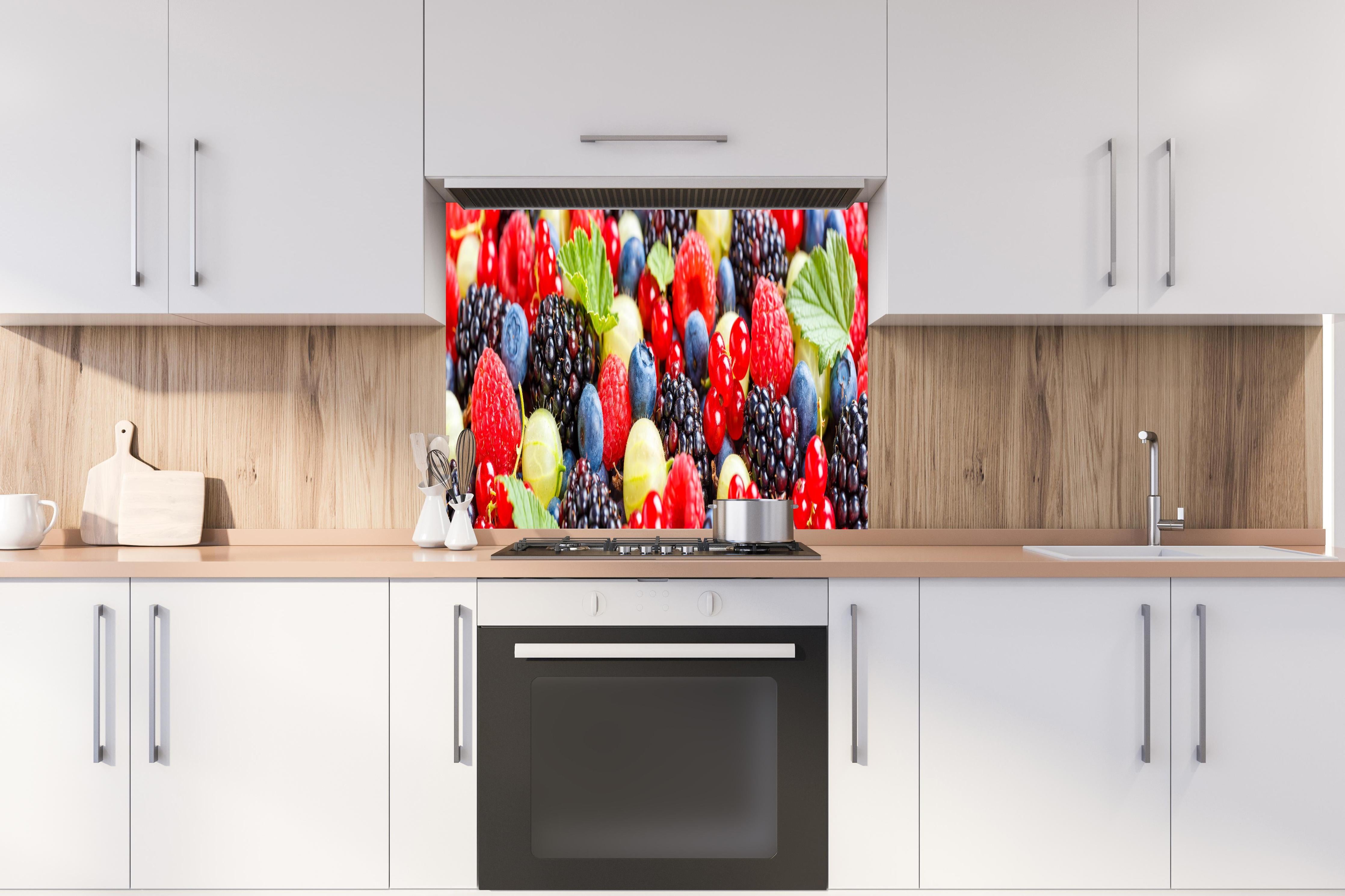 Spritzschutz - Beerenmischung hinter einem Cerankochfeld zwischen Holz-Kochutensilien