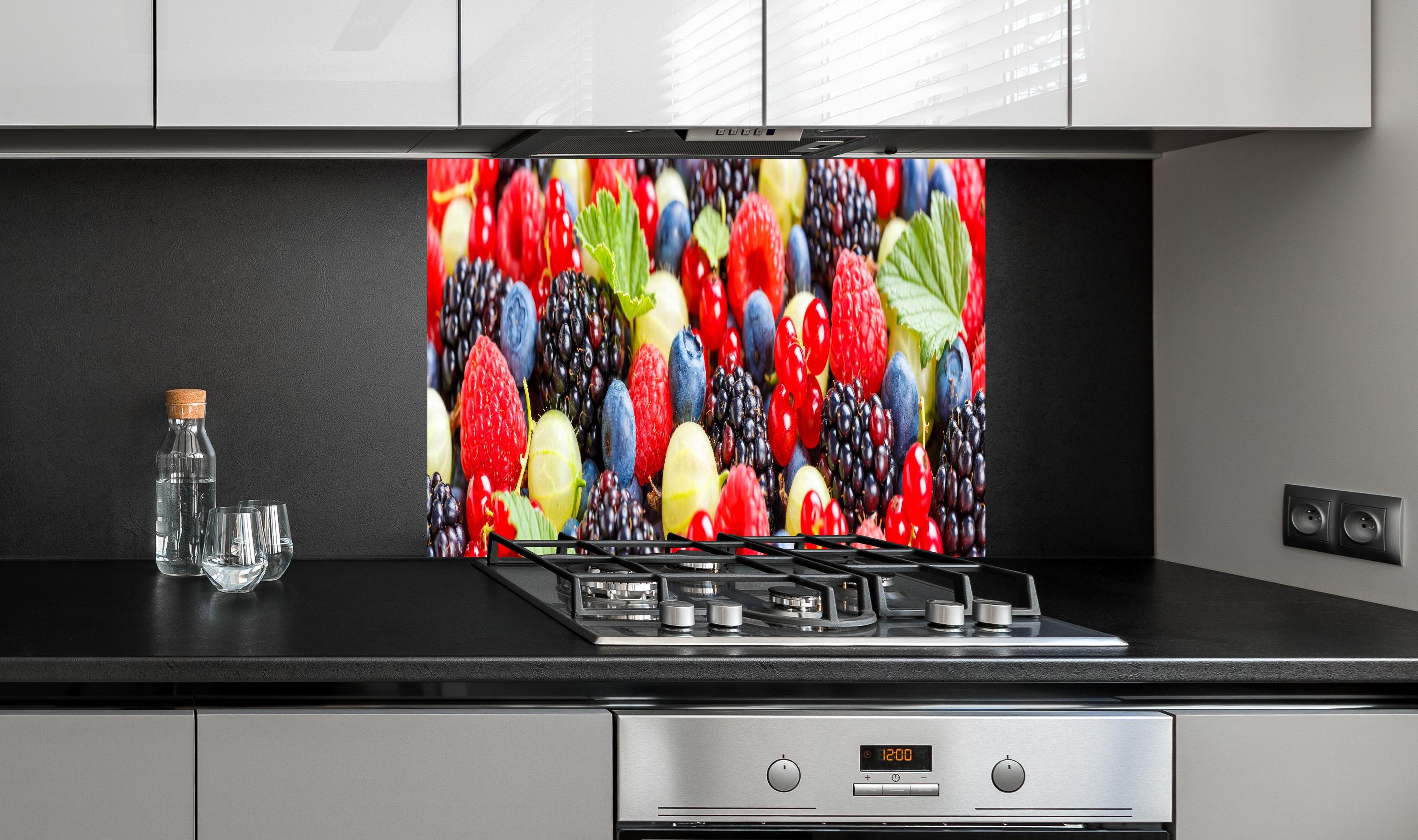 Spritzschutz - Beerenmischung hinter einem Cerankochfeld zwischen Holz-Kochutensilien