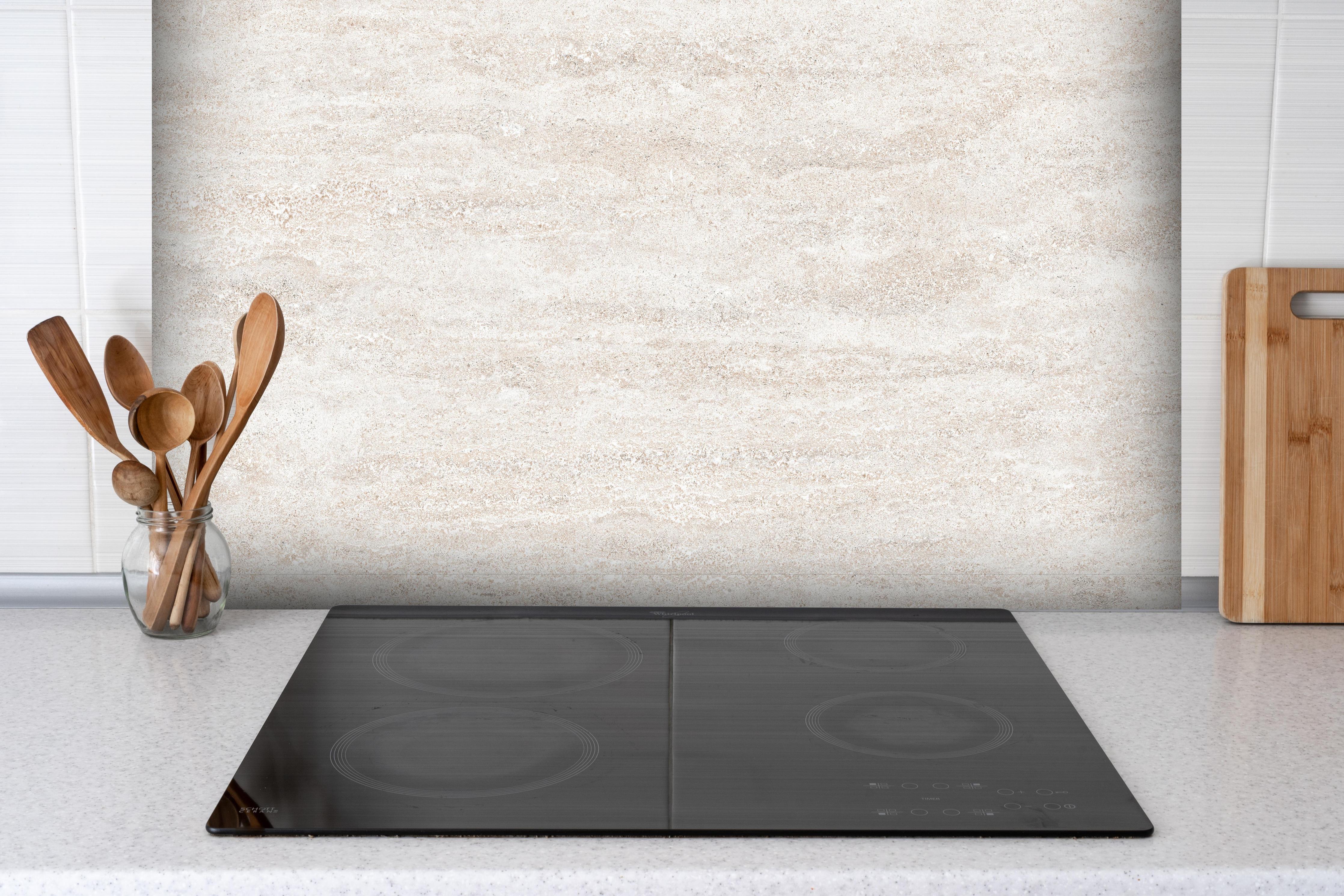 Spritzschutz - Beige Marmor Textur hinter einem Cerankochfeld zwischen Holz-Kochutensilien