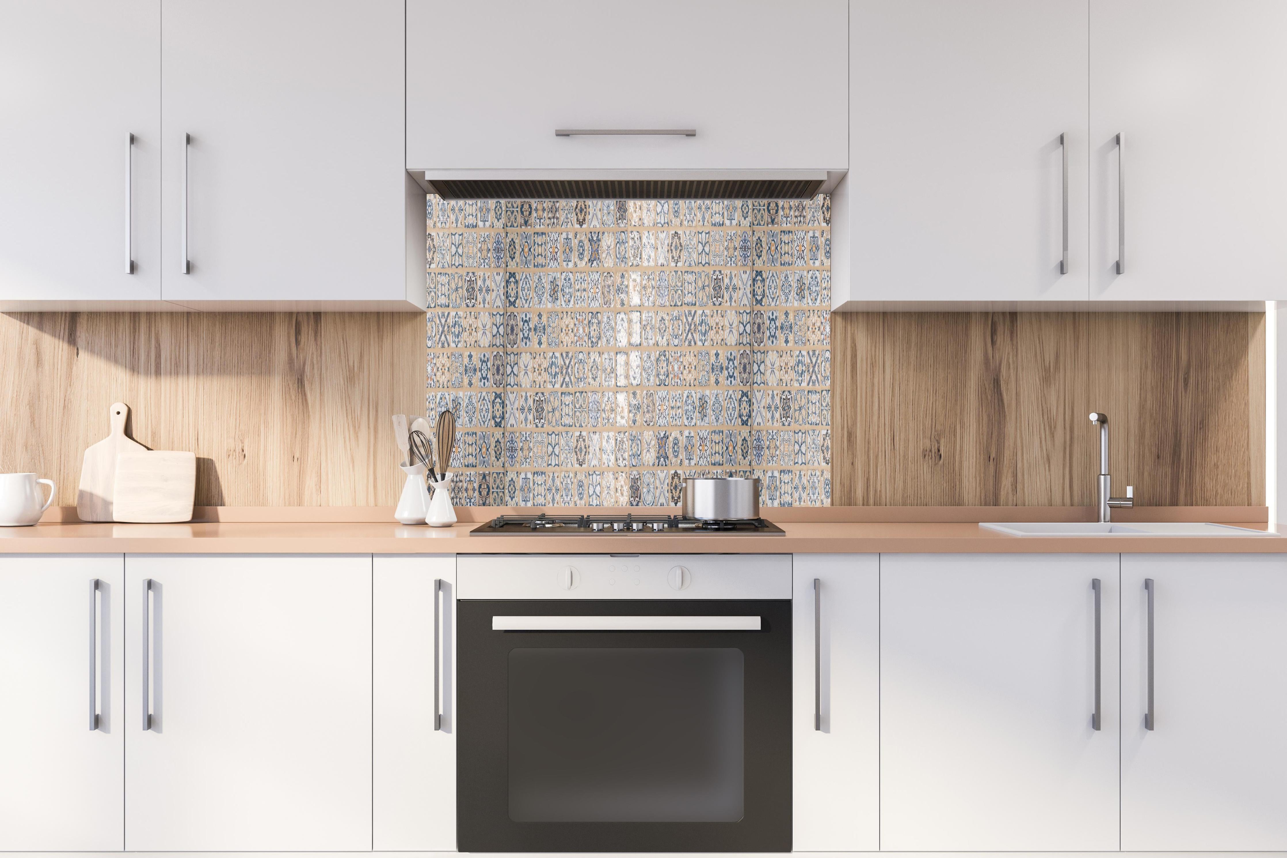Spritzschutz - Beige-blau Vintage Mosaik hinter einem Cerankochfeld zwischen Holz-Kochutensilien