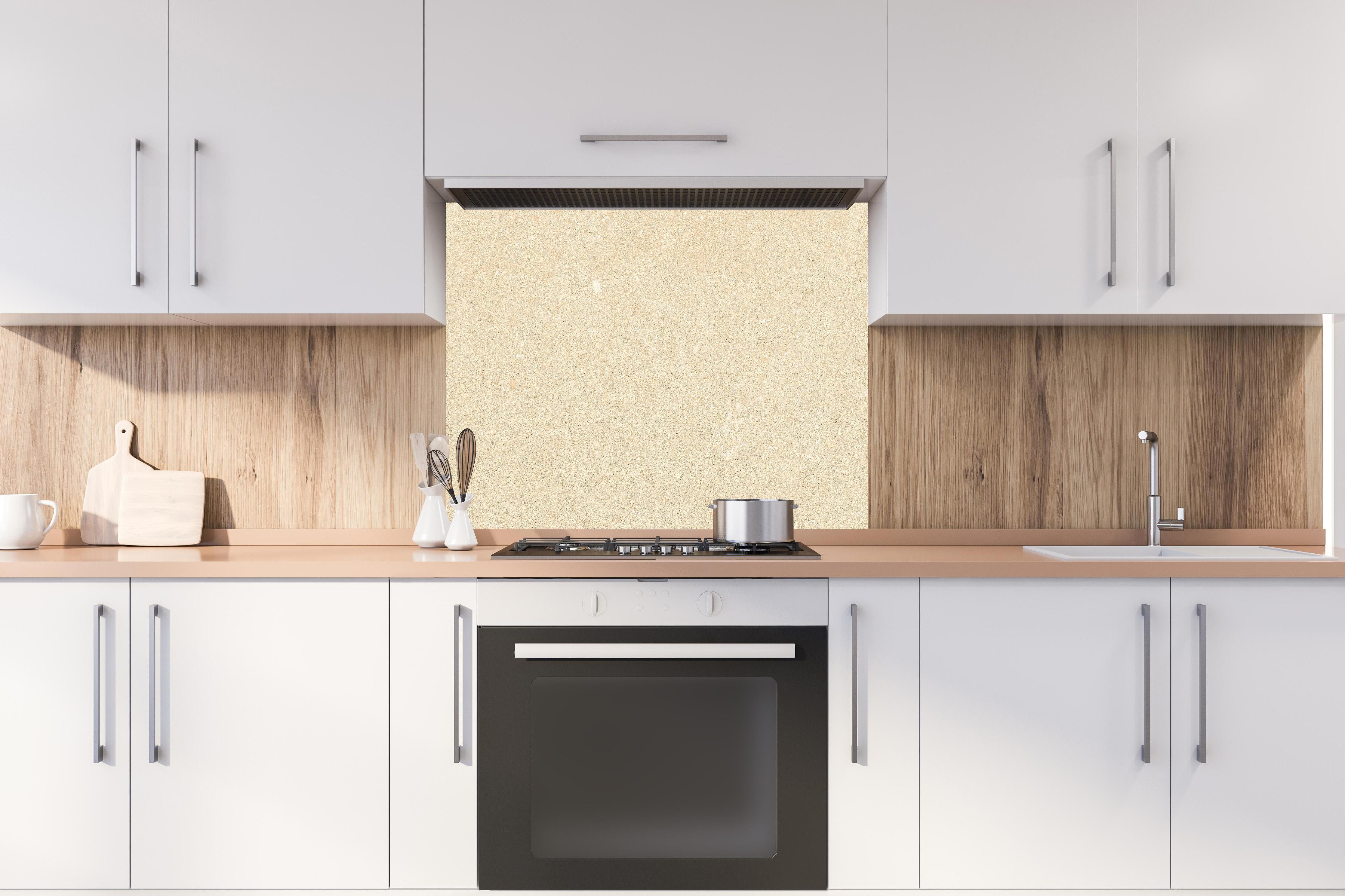 Spritzschutz - Beiger Marmor hinter einem Cerankochfeld zwischen Holz-Kochutensilien