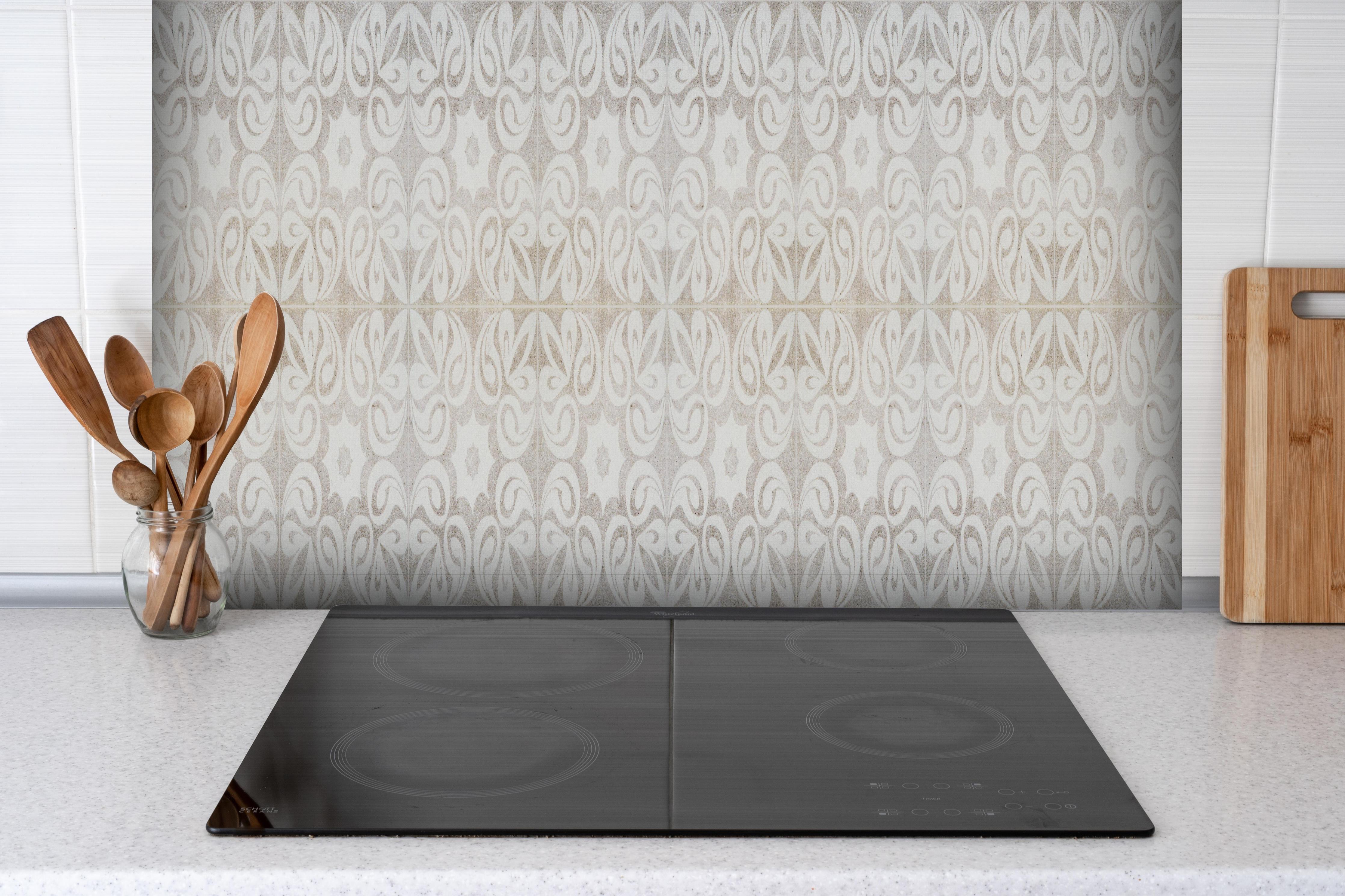 Spritzschutz - Beiges quadratisches Mosaikmotiv hinter einem Cerankochfeld zwischen Holz-Kochutensilien