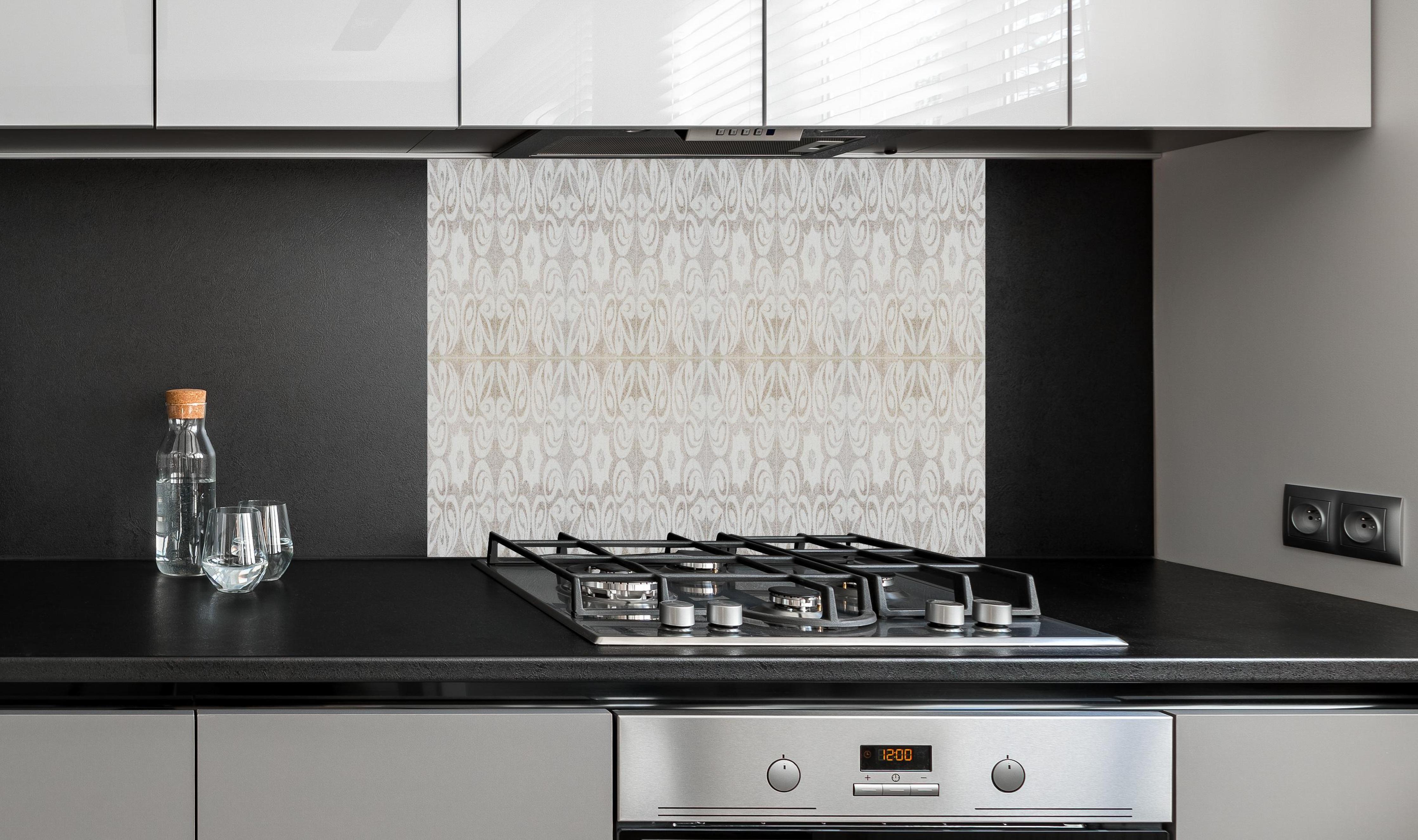 Spritzschutz - Beiges quadratisches Mosaikmotiv hinter einem Cerankochfeld zwischen Holz-Kochutensilien