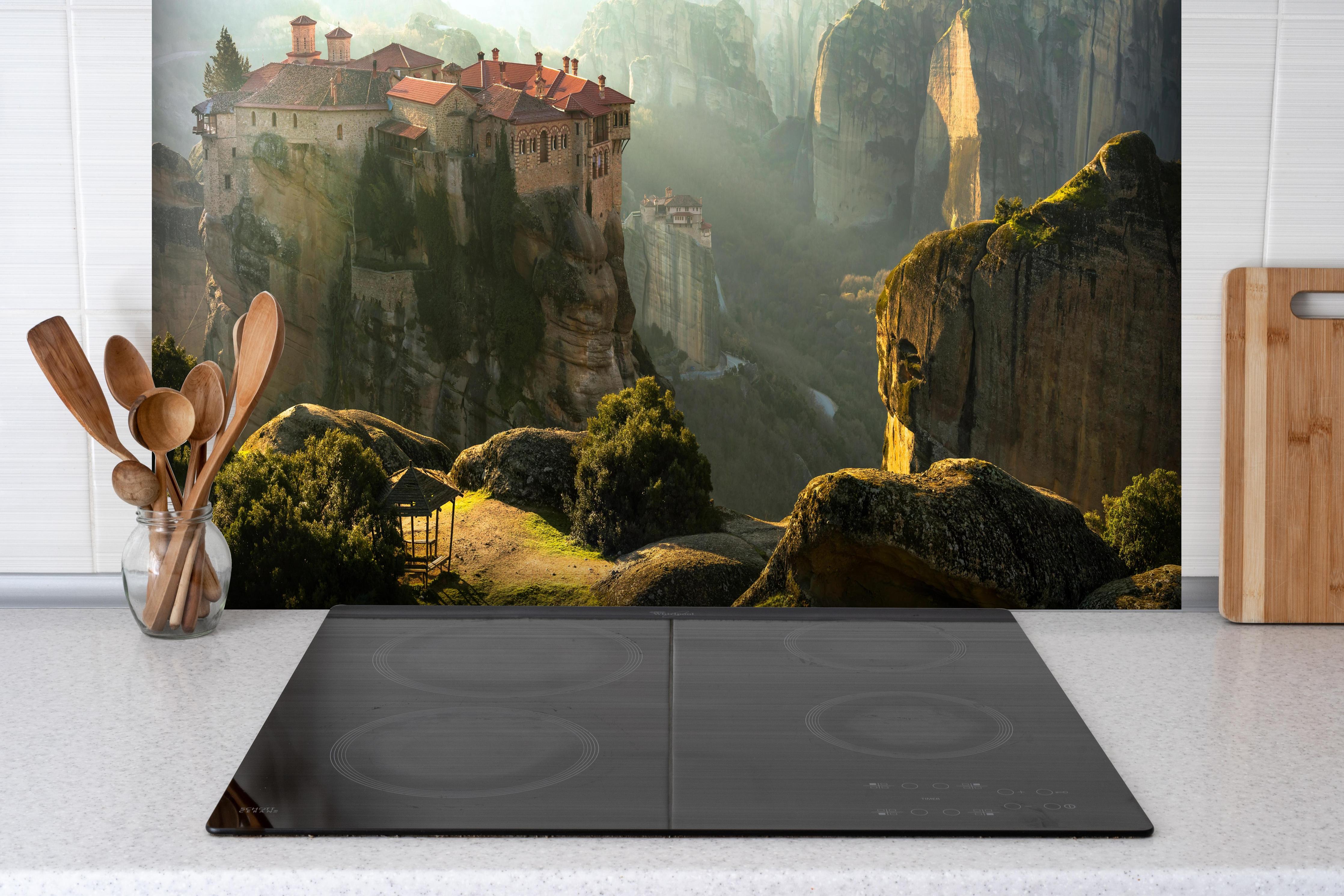 Spritzschutz - Bergkloster in Abendlicht-Mystik hinter einem Cerankochfeld zwischen Holz-Kochutensilien