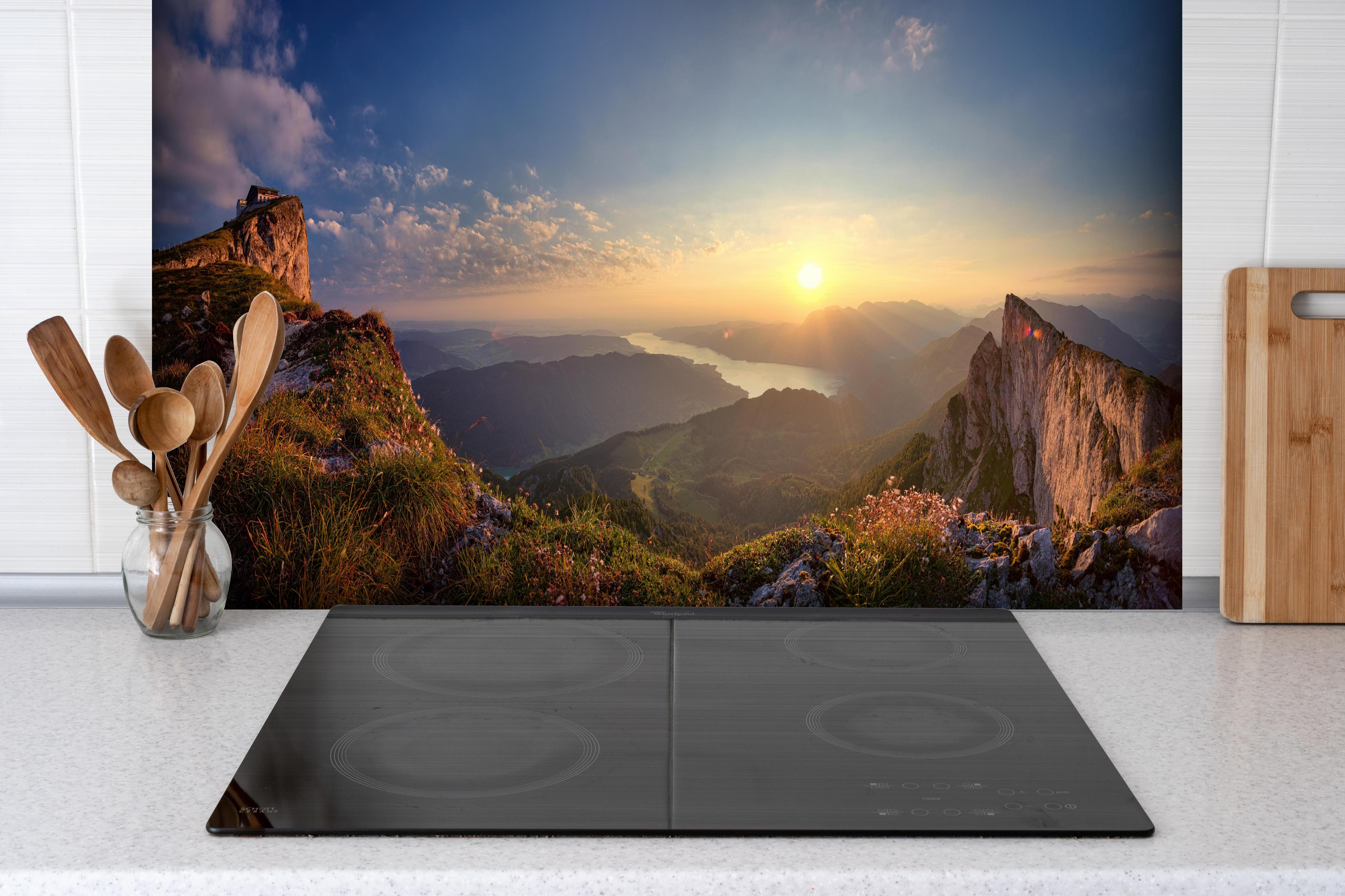 Spritzschutz - Berglandschafts Panorama hinter einem Cerankochfeld zwischen Holz-Kochutensilien