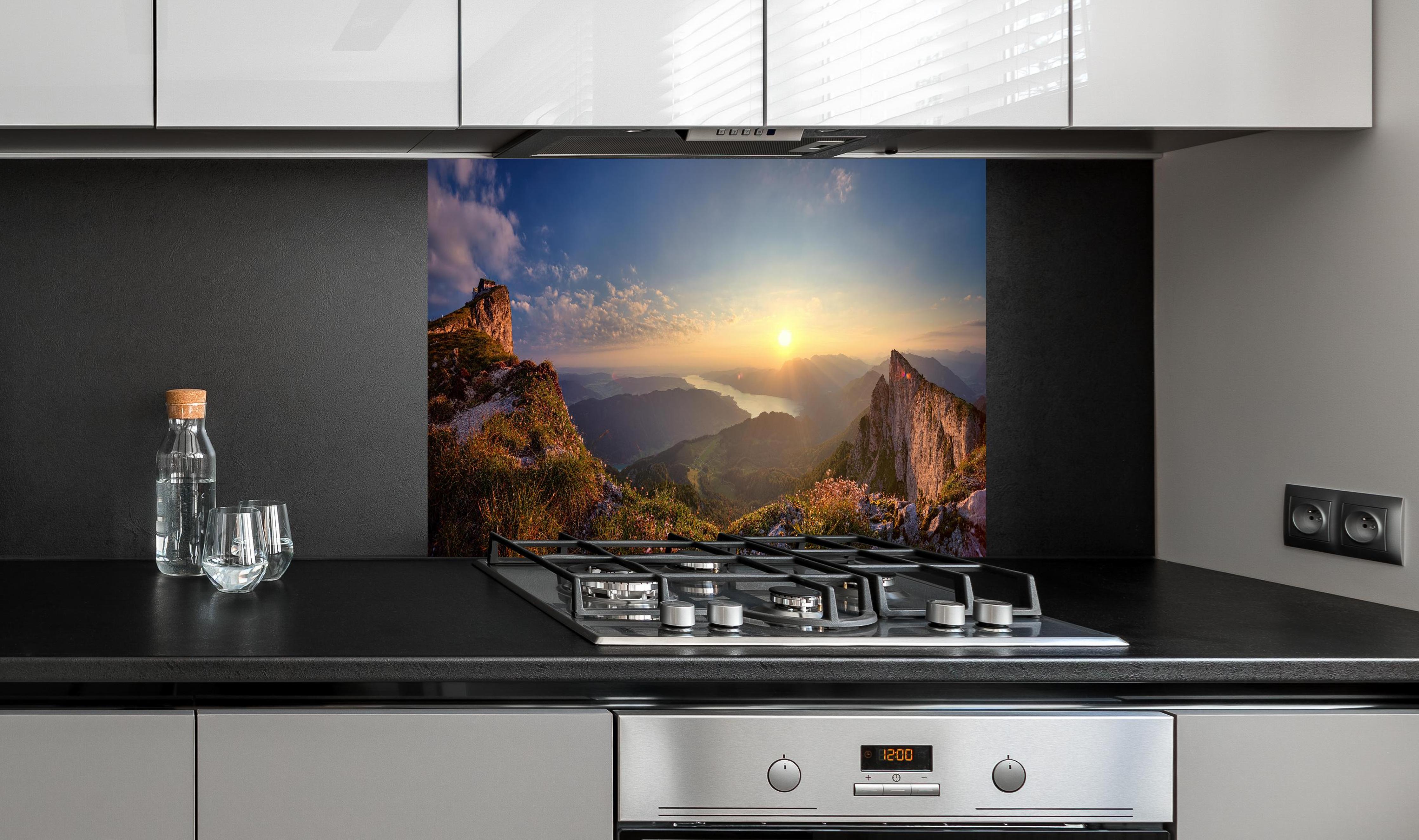 Spritzschutz - Berglandschafts Panorama hinter einem Cerankochfeld zwischen Holz-Kochutensilien