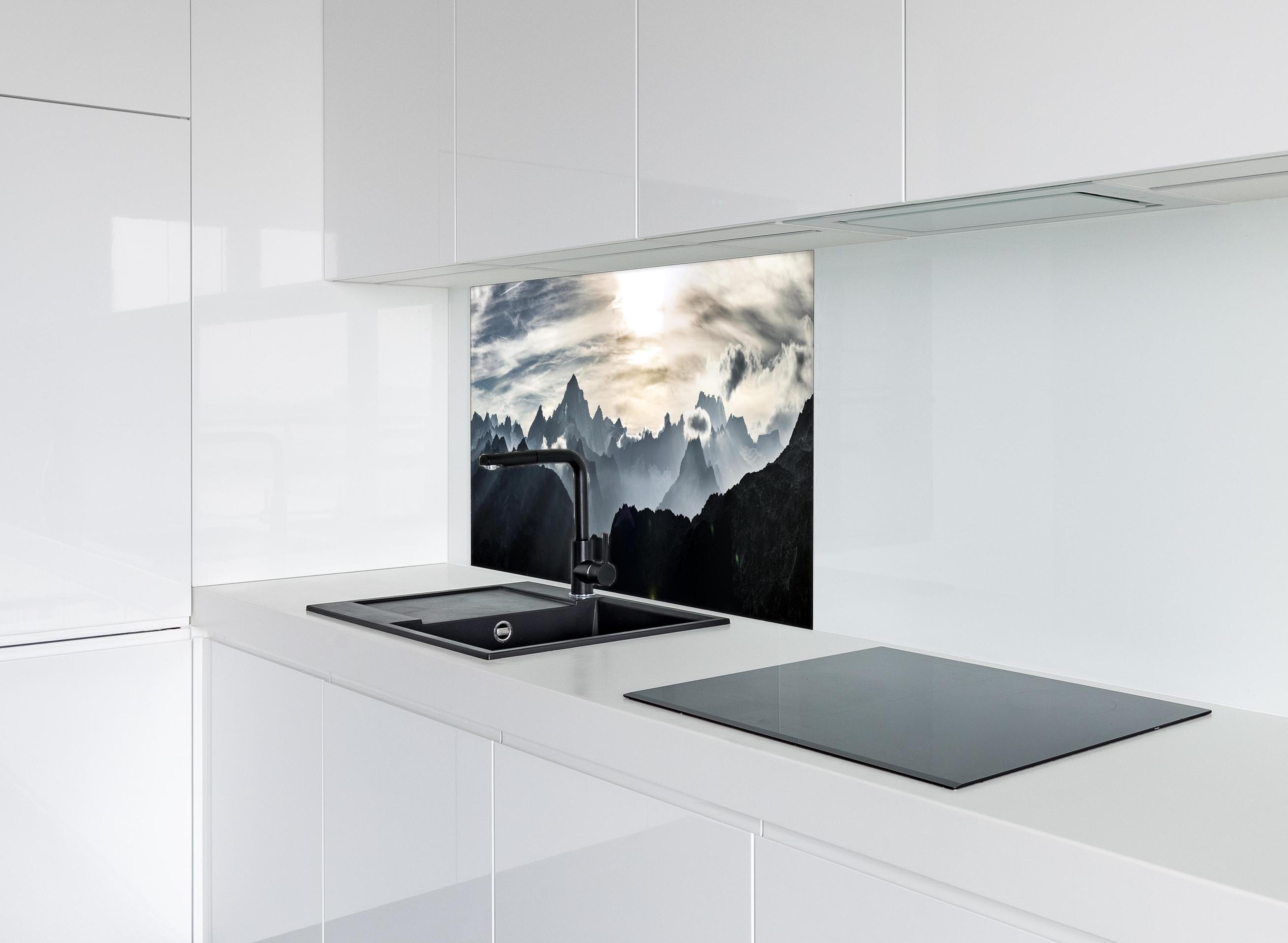 Spritzschutz - Bergpanorama mit Sonnenuntergangslicht hinter einem Cerankochfeld zwischen Holz-Kochutensilien