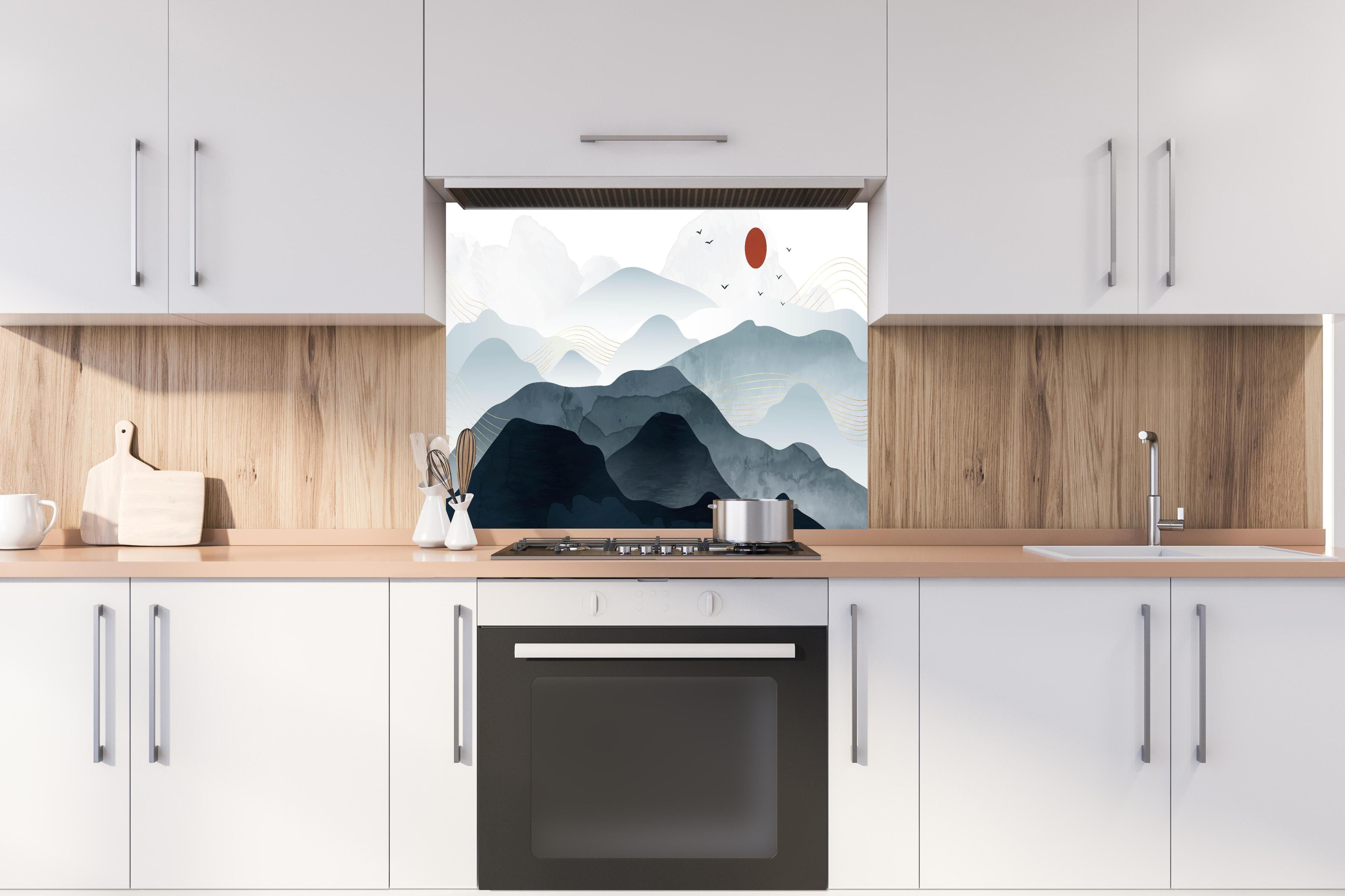 Spritzschutz - Bergpanorama mit rotem Sonnenkreis Kunst hinter einem Cerankochfeld zwischen Holz-Kochutensilien