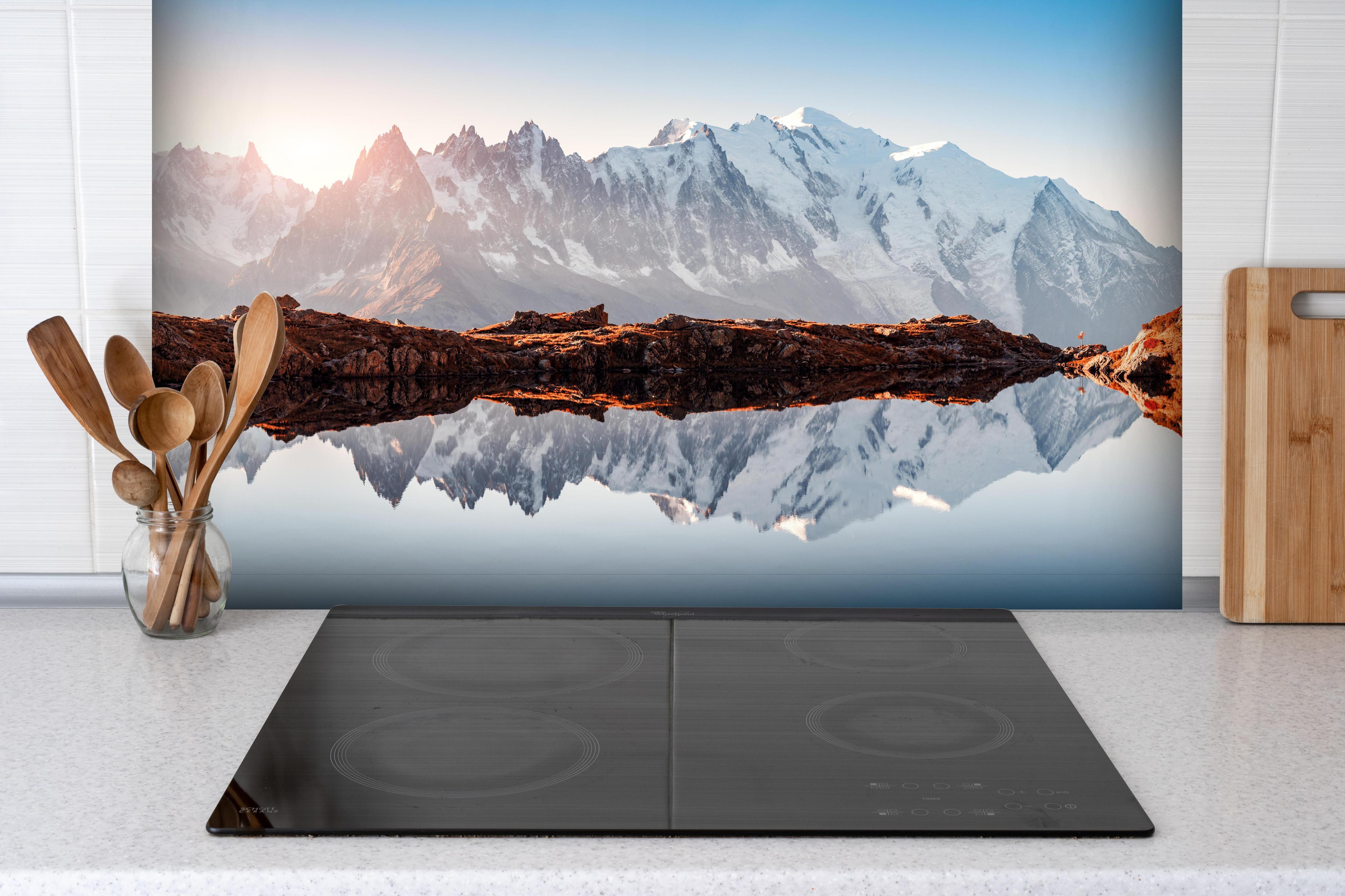 Spritzschutz - Bergspiegelung im Lac Blanc See hinter einem Cerankochfeld zwischen Holz-Kochutensilien