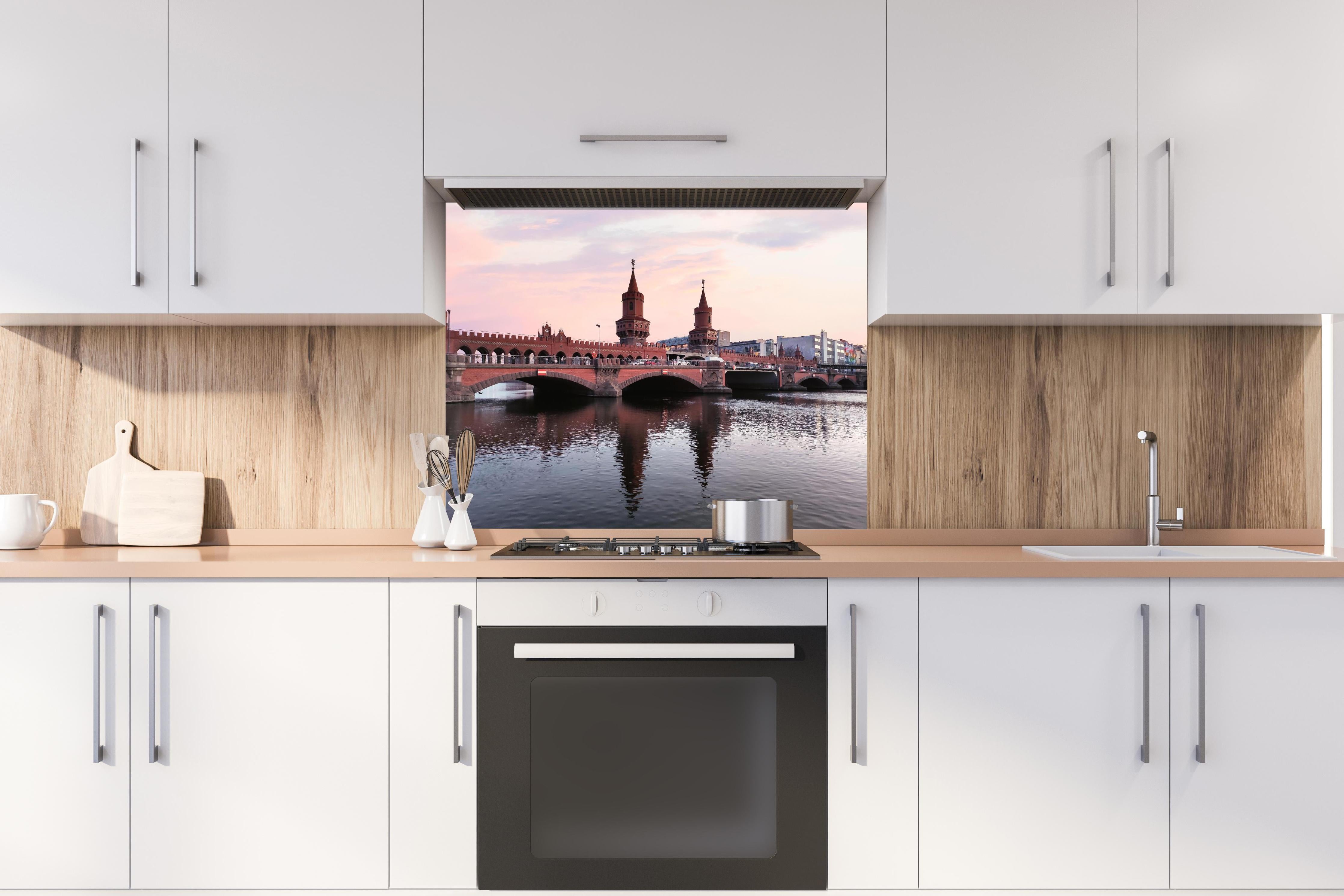 Spritzschutz - Berliner Brücke bei Tag hinter einem Cerankochfeld zwischen Holz-Kochutensilien