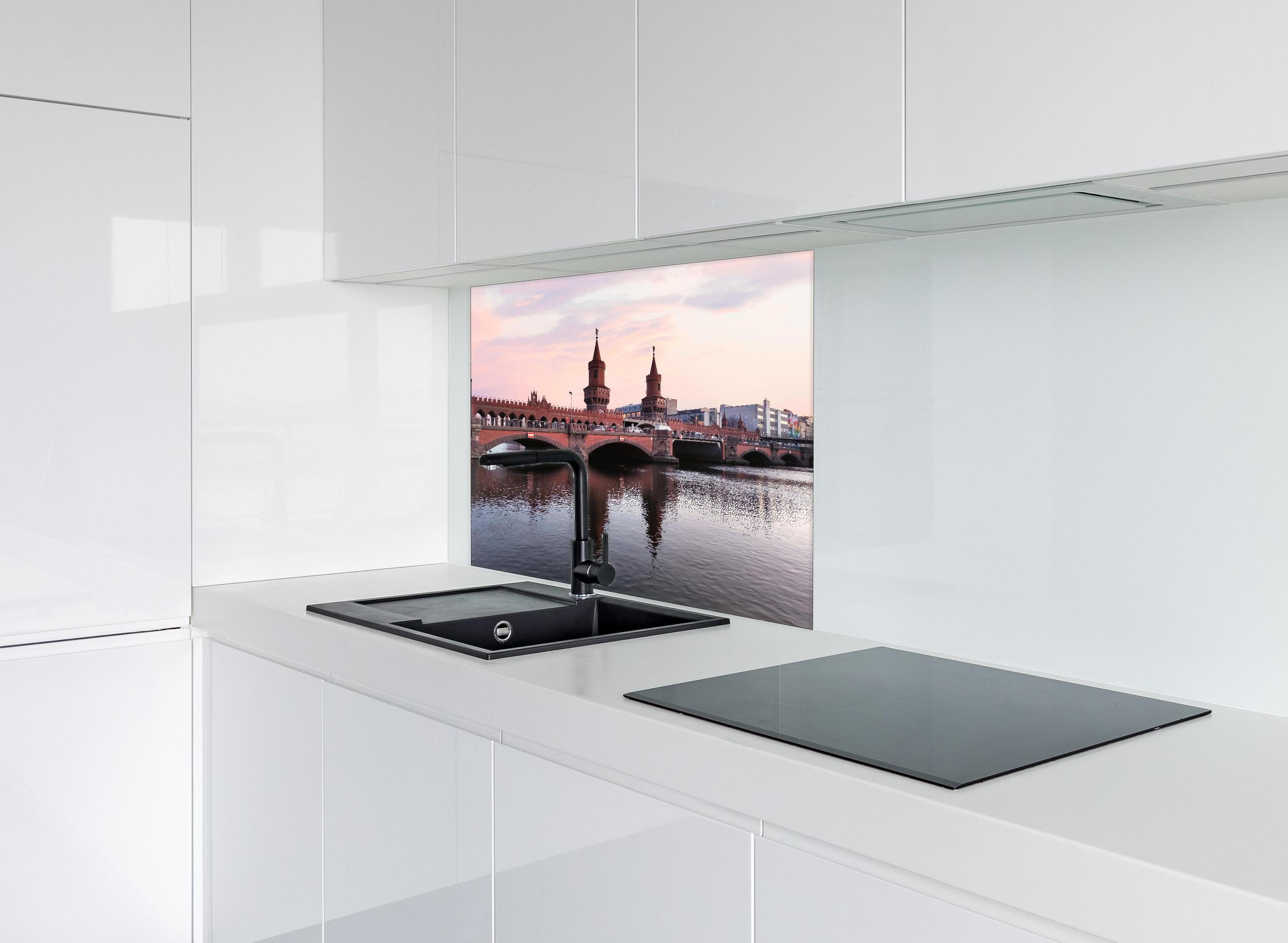 Spritzschutz - Berliner Brücke bei Tag hinter einem Cerankochfeld zwischen Holz-Kochutensilien