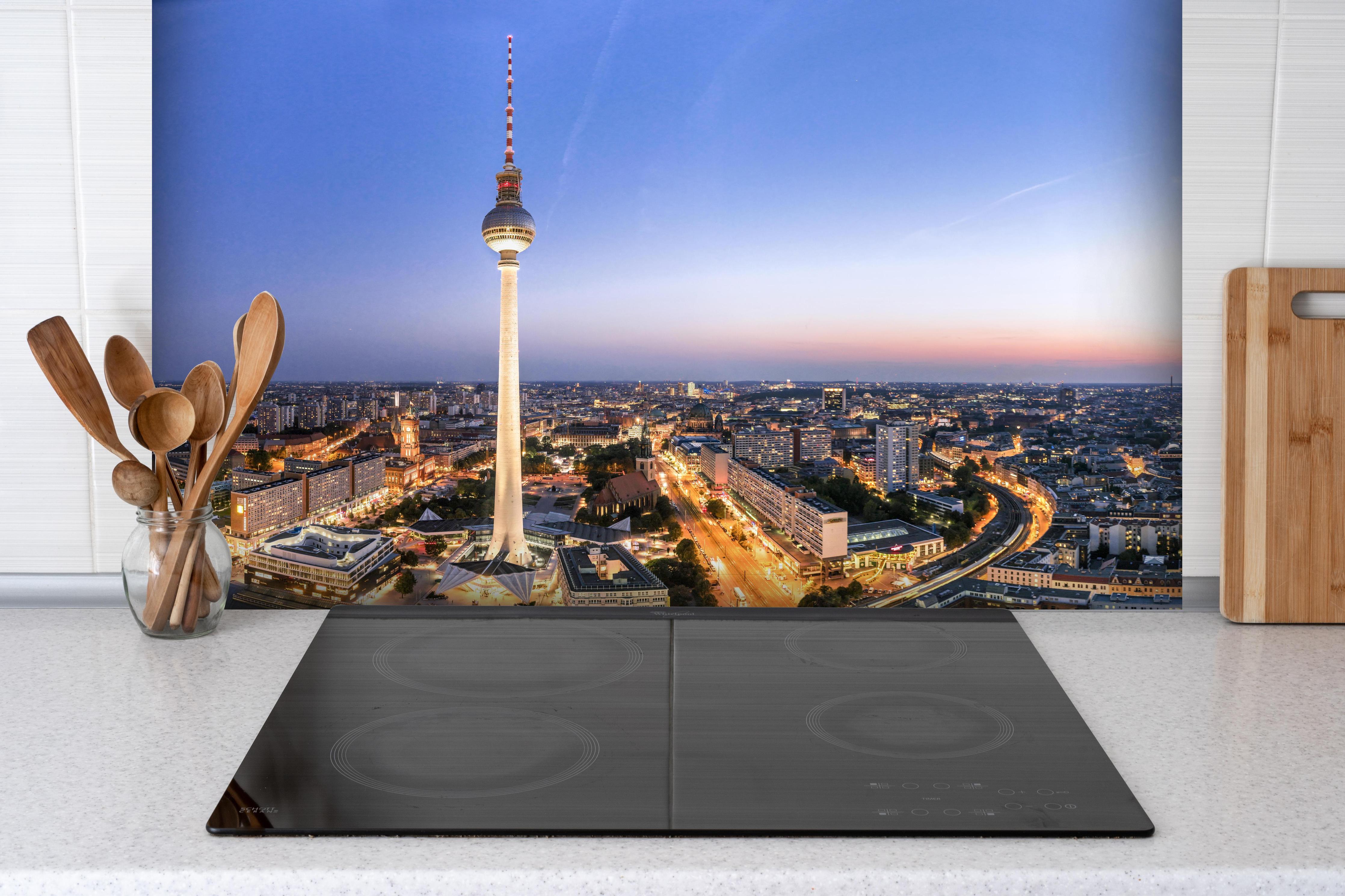 Spritzschutz - Berliner Fernsehturm hinter einem Cerankochfeld zwischen Holz-Kochutensilien