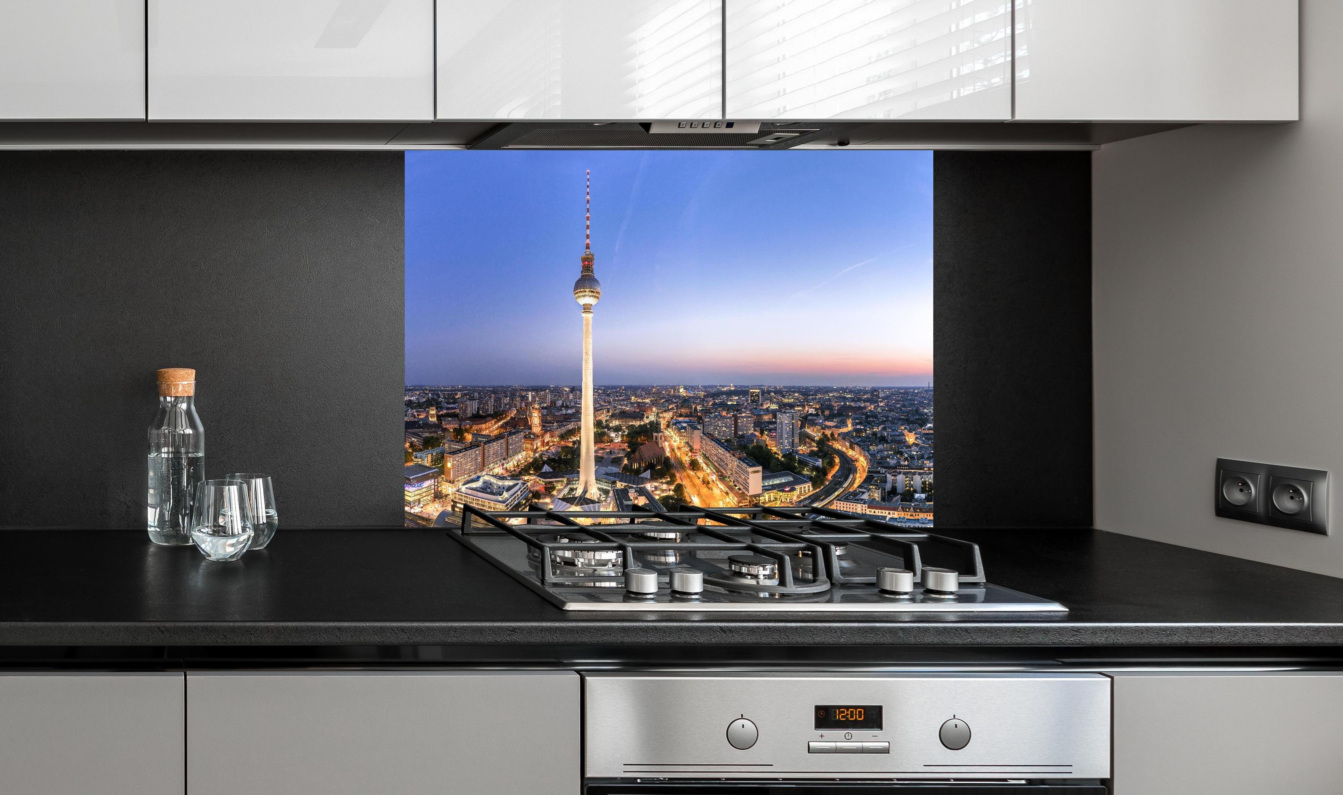 Spritzschutz - Berliner Fernsehturm hinter einem Cerankochfeld zwischen Holz-Kochutensilien
