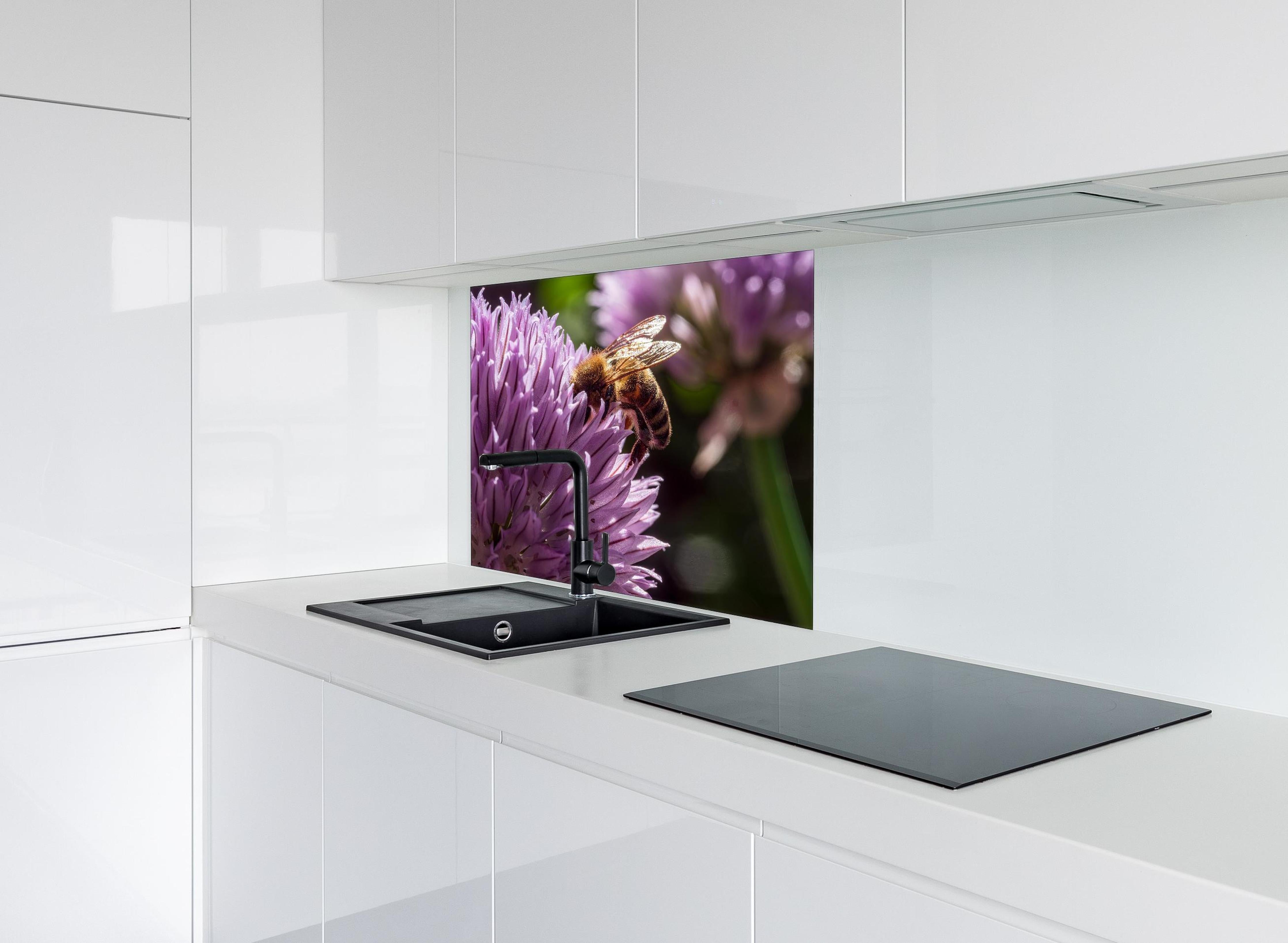 Spritzschutz - Biene auf lila Blüte Makroaufnahme hinter einem Cerankochfeld zwischen Holz-Kochutensilien