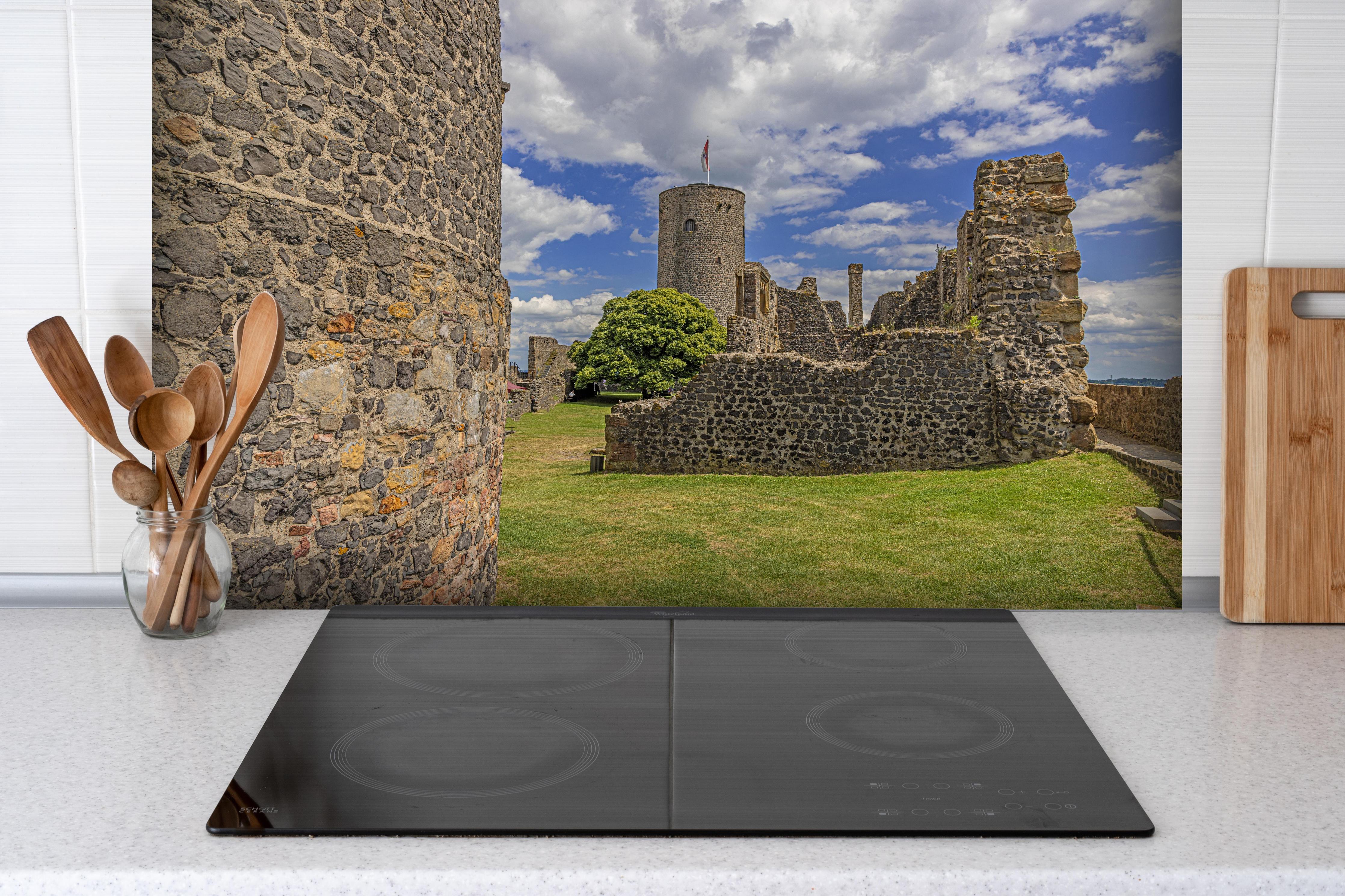 Spritzschutz - Bild von der Burgruine Münzenberg in Hessen hinter einem Cerankochfeld zwischen Holz-Kochutensilien