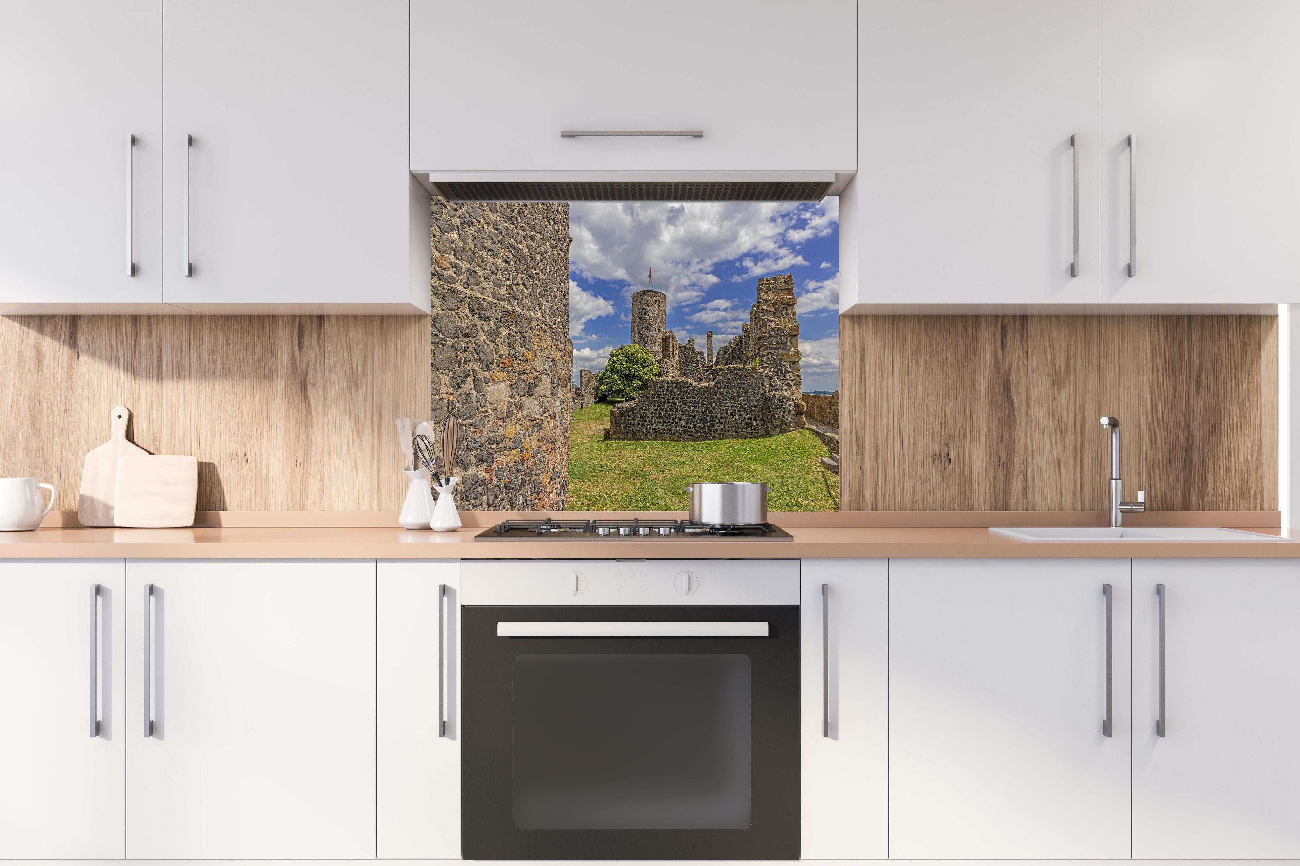 Spritzschutz - Bild von der Burgruine Münzenberg in Hessen hinter einem Cerankochfeld zwischen Holz-Kochutensilien