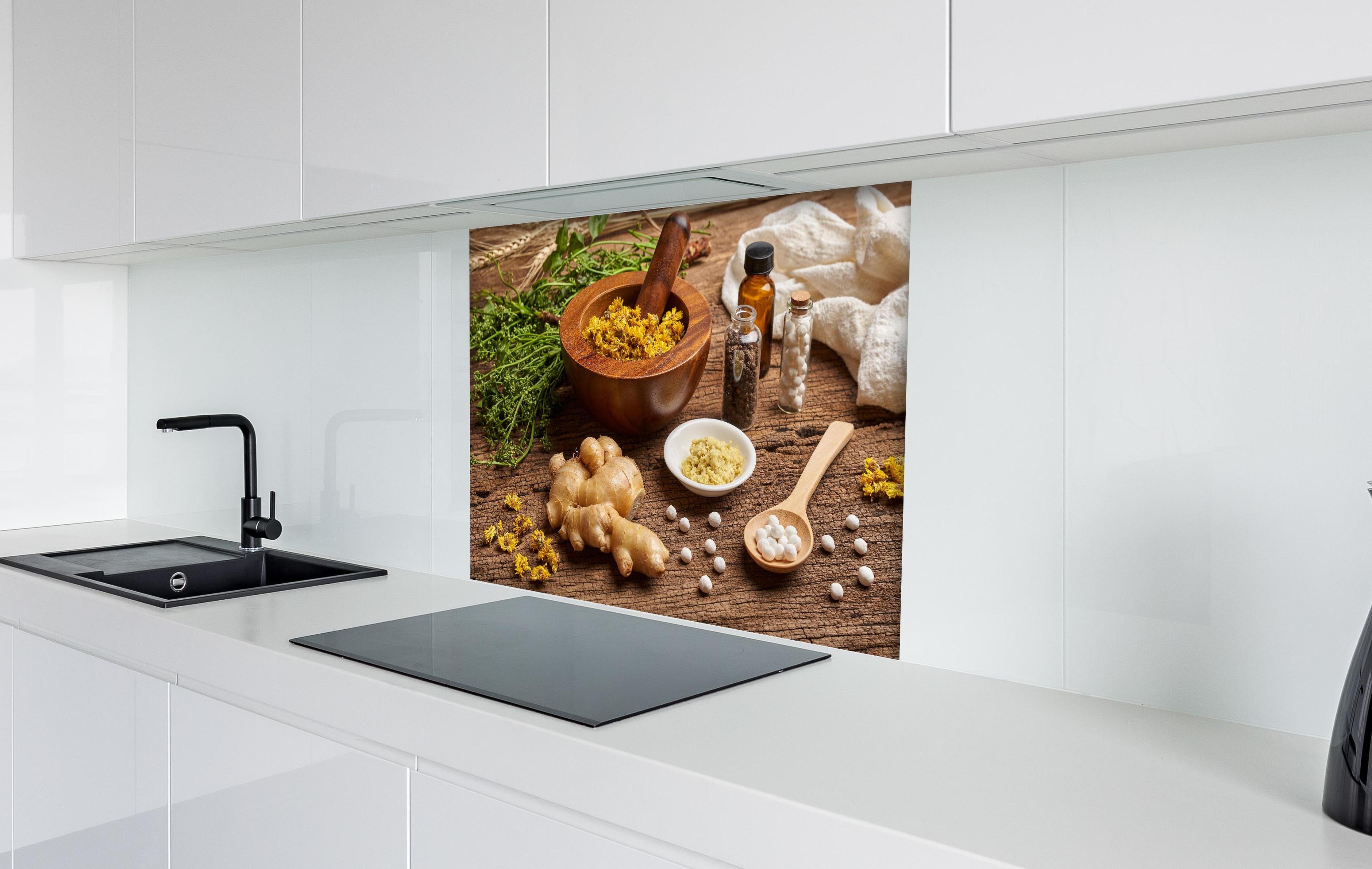Spritzschutz - Bio Heilkräuter und Naturheilmittel Wellness hinter einem Cerankochfeld zwischen Holz-Kochutensilien