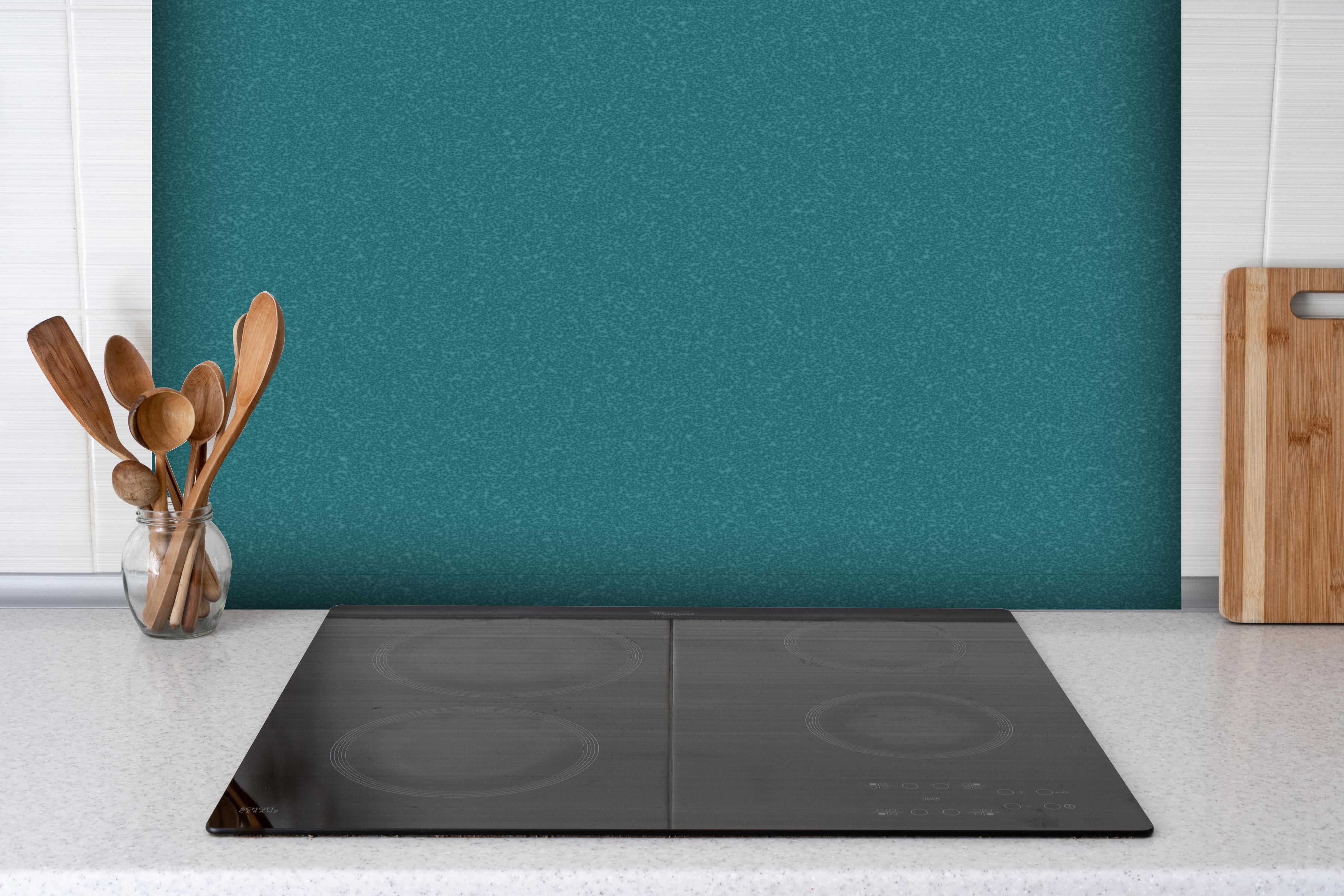 Spritzschutz - Bläuliche Wandtextur - Blaue Hafenfarbe hinter einem Cerankochfeld zwischen Holz-Kochutensilien