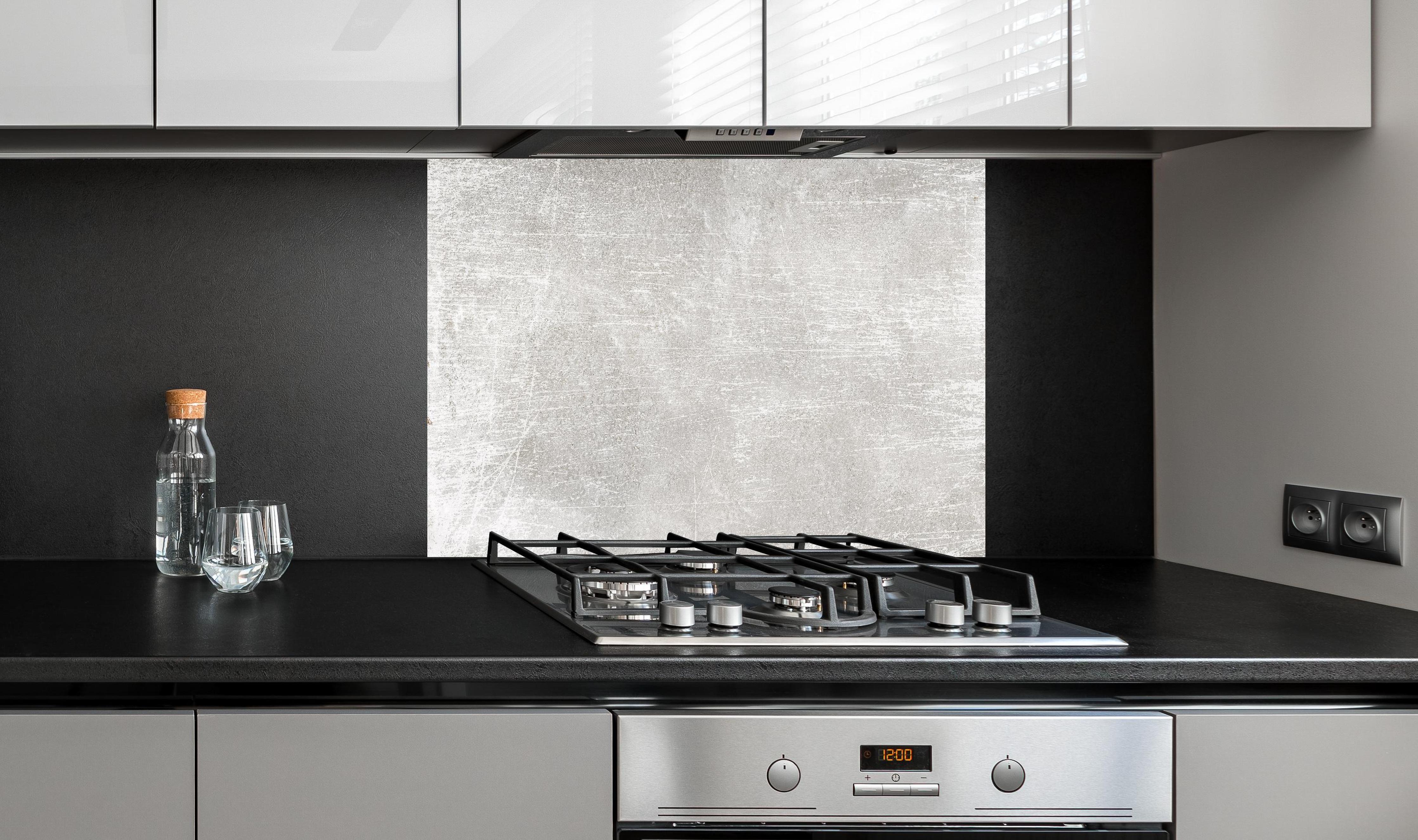 Spritzschutz - Blanker Zement Hintergrund hinter einem Cerankochfeld zwischen Holz-Kochutensilien