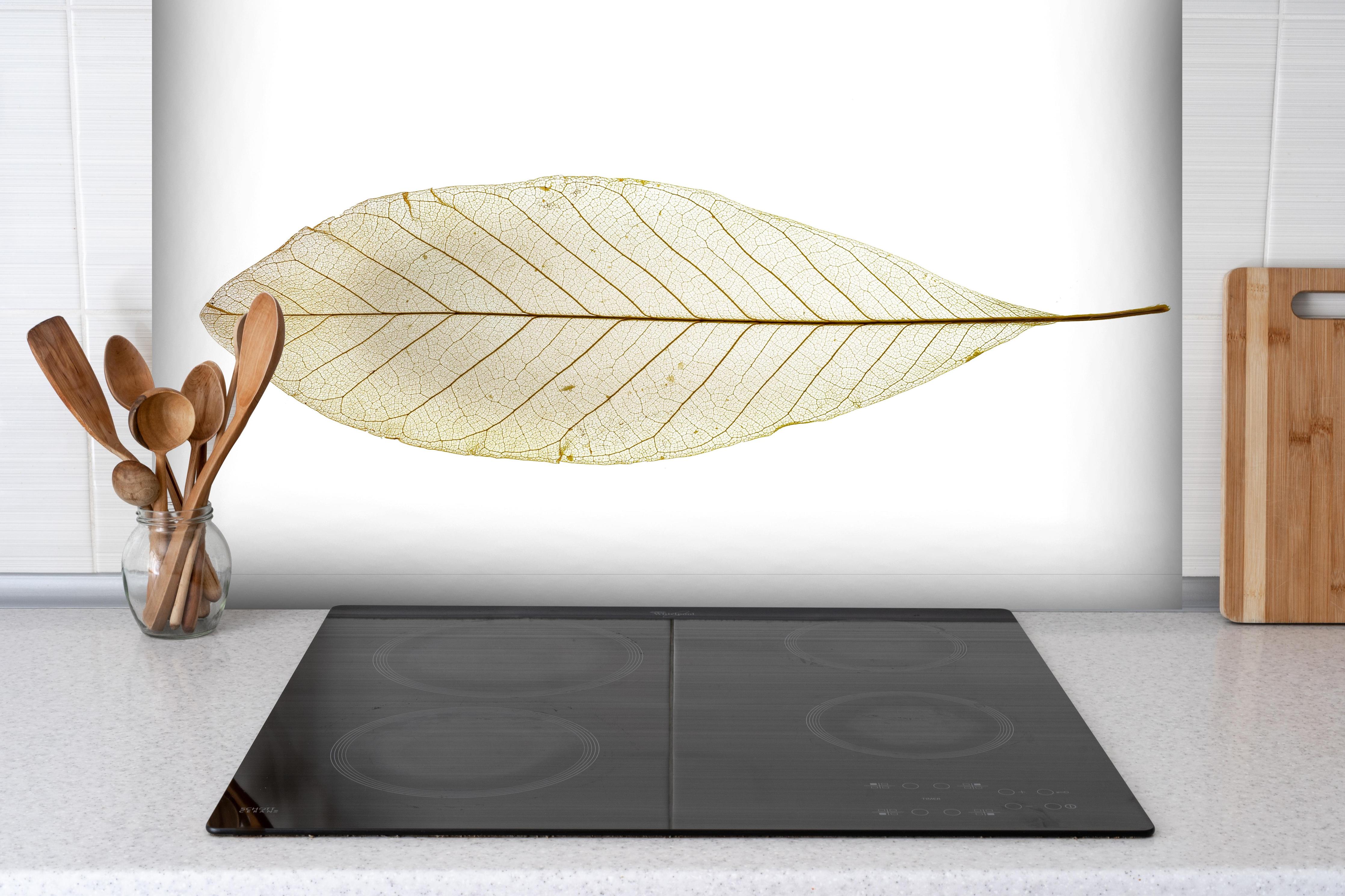 Spritzschutz - Blatt-Textur-Muster hinter einem Cerankochfeld zwischen Holz-Kochutensilien