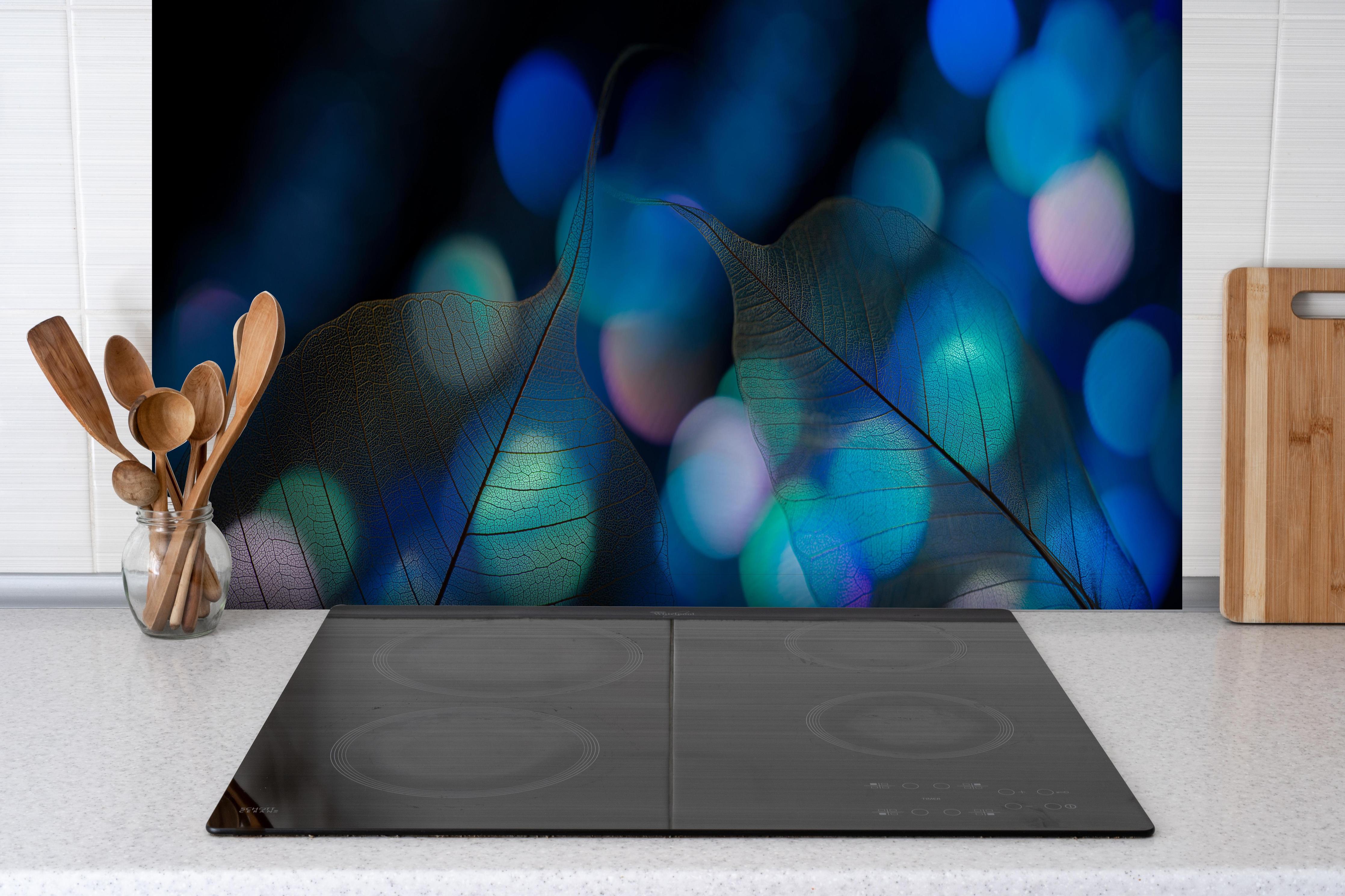 Spritzschutz - Blattadern Textur mit Bokeh Lichteffekt hinter einem Cerankochfeld zwischen Holz-Kochutensilien