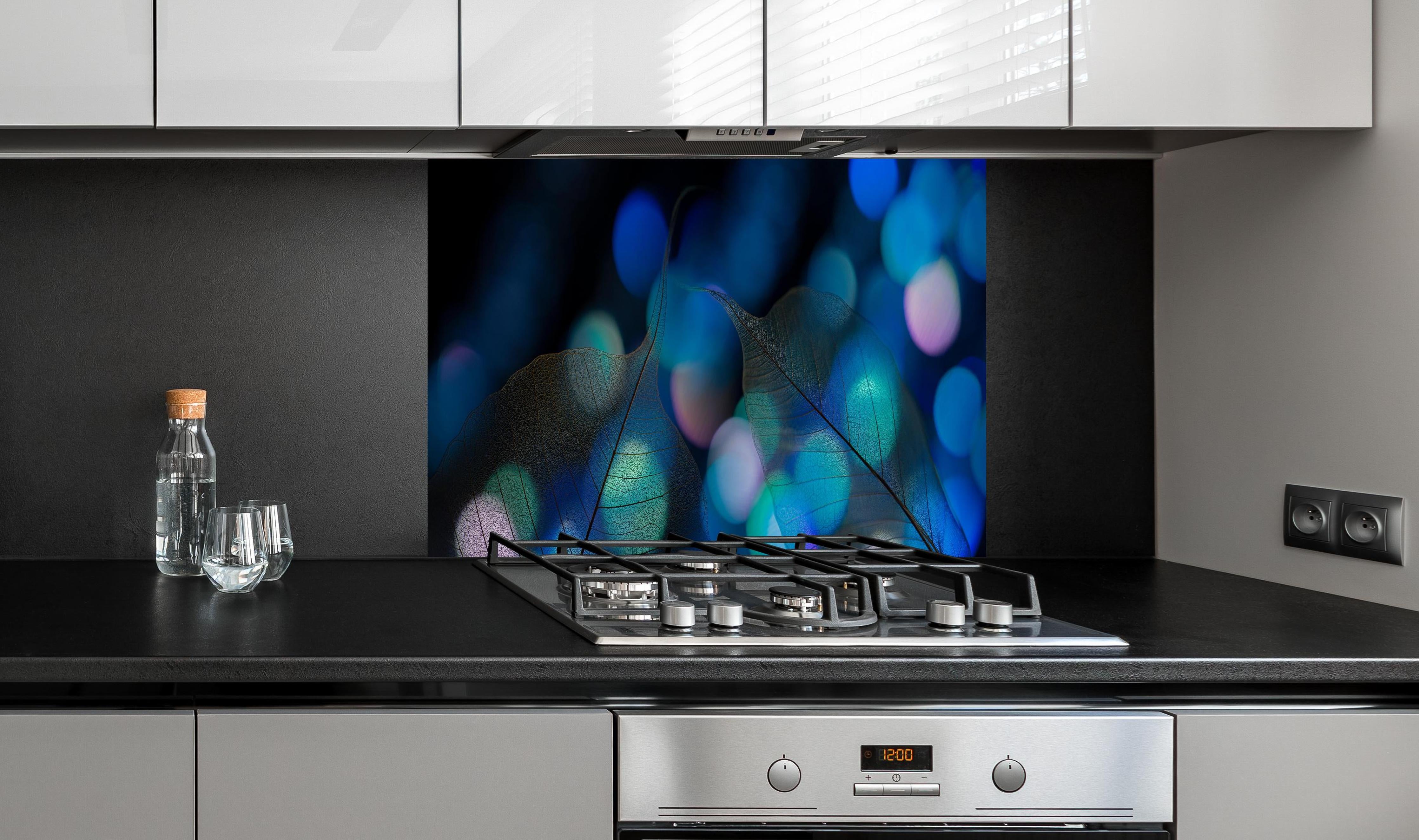 Spritzschutz - Blattadern Textur mit Bokeh Lichteffekt hinter einem Cerankochfeld zwischen Holz-Kochutensilien