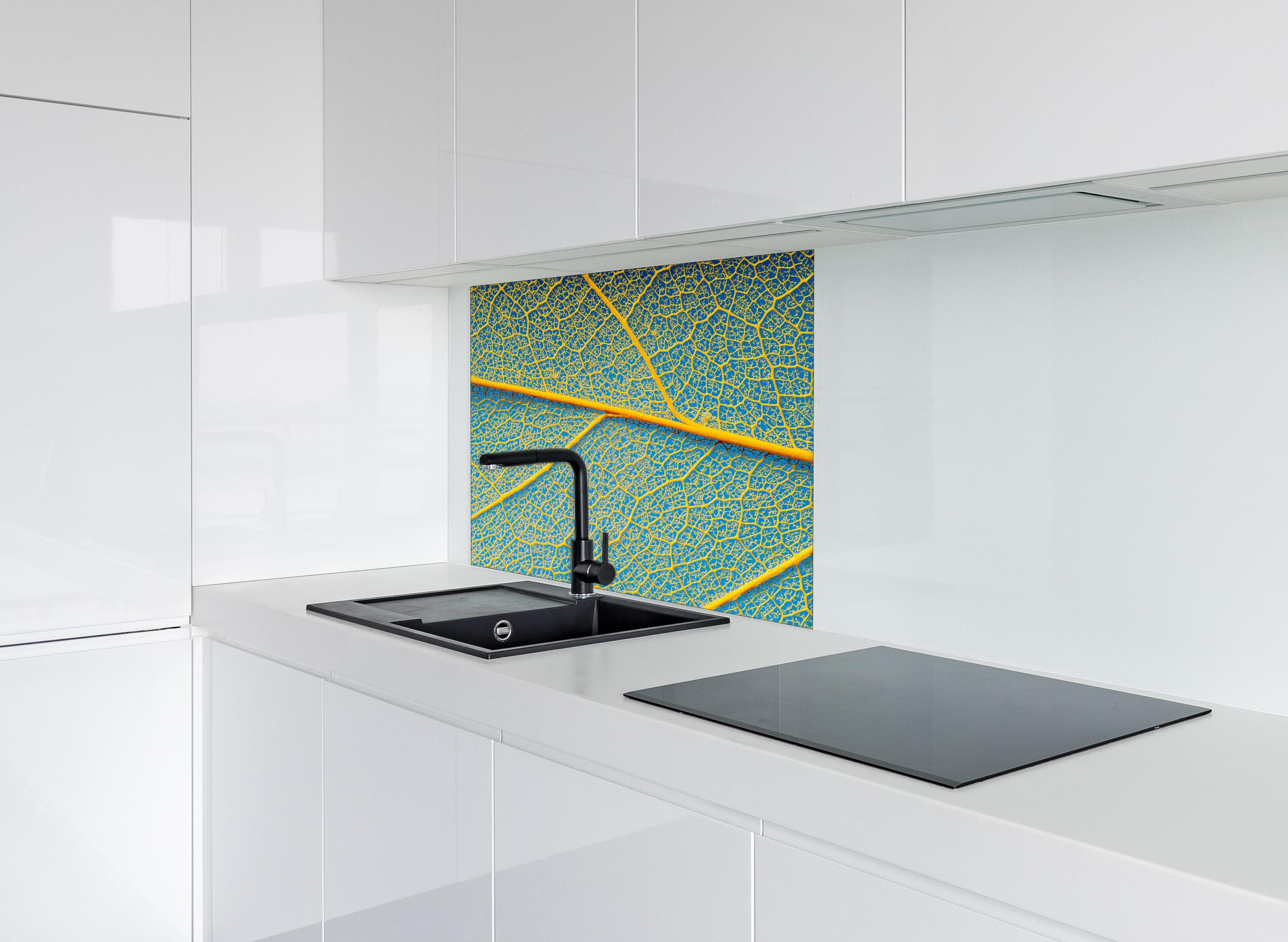 Spritzschutz - Blattstruktur in Makroaufnahme Gelb-Blau hinter einem Cerankochfeld zwischen Holz-Kochutensilien