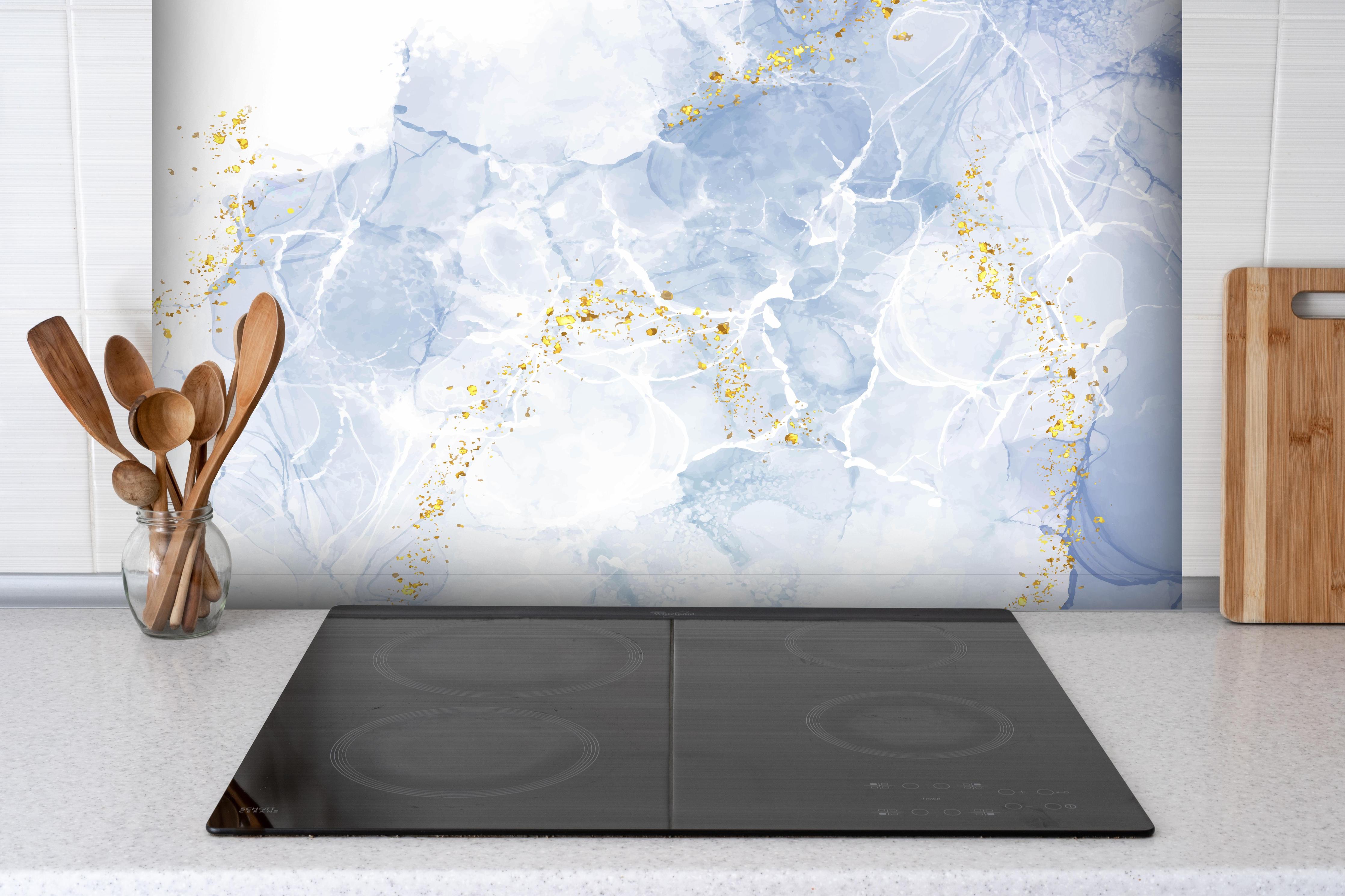 Spritzschutz - Blau-Weiß-Marmor mit goldener Textur hinter einem Cerankochfeld zwischen Holz-Kochutensilien