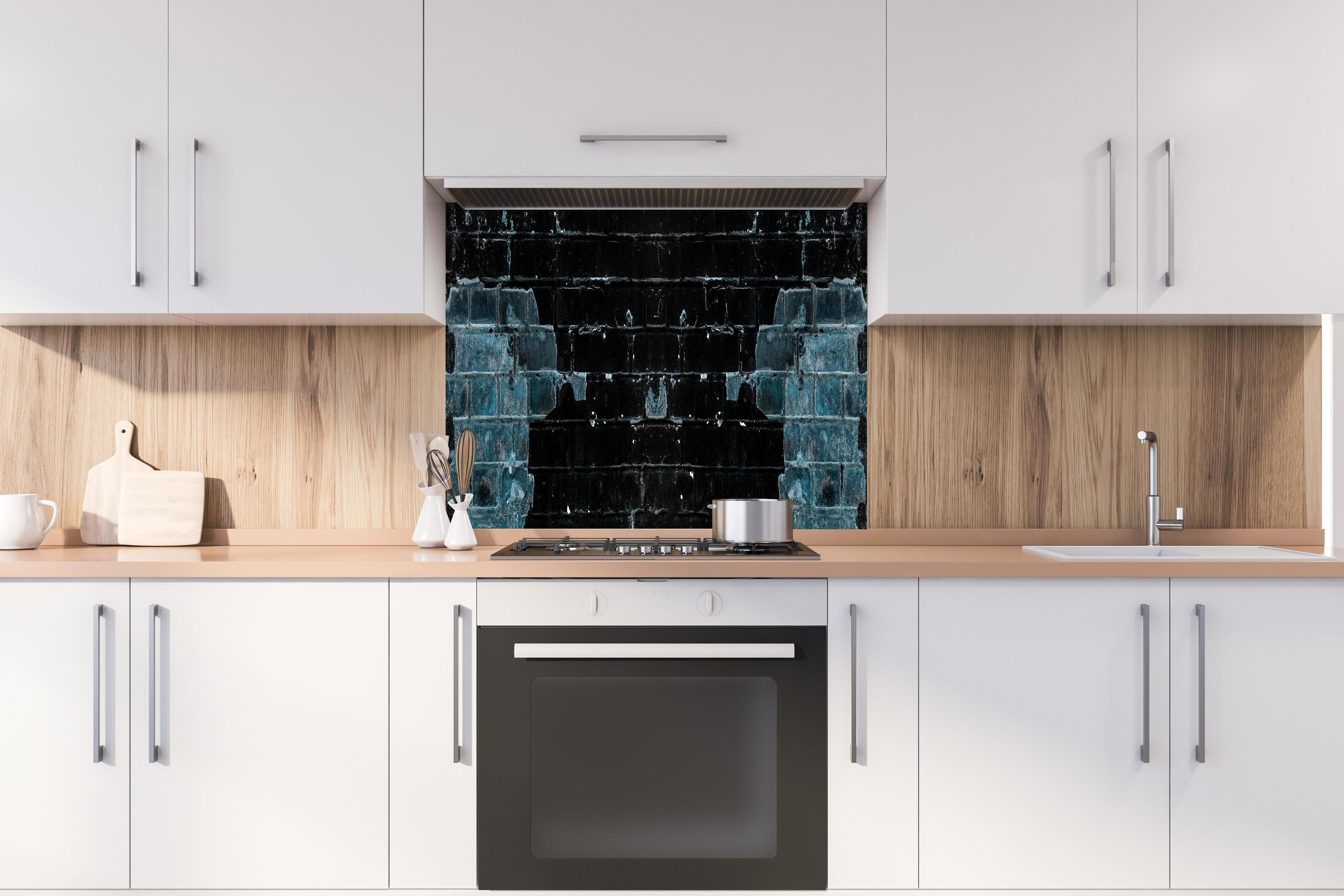 Spritzschutz - Blau schwarz beschädigte Ziegelwand hinter einem Cerankochfeld zwischen Holz-Kochutensilien