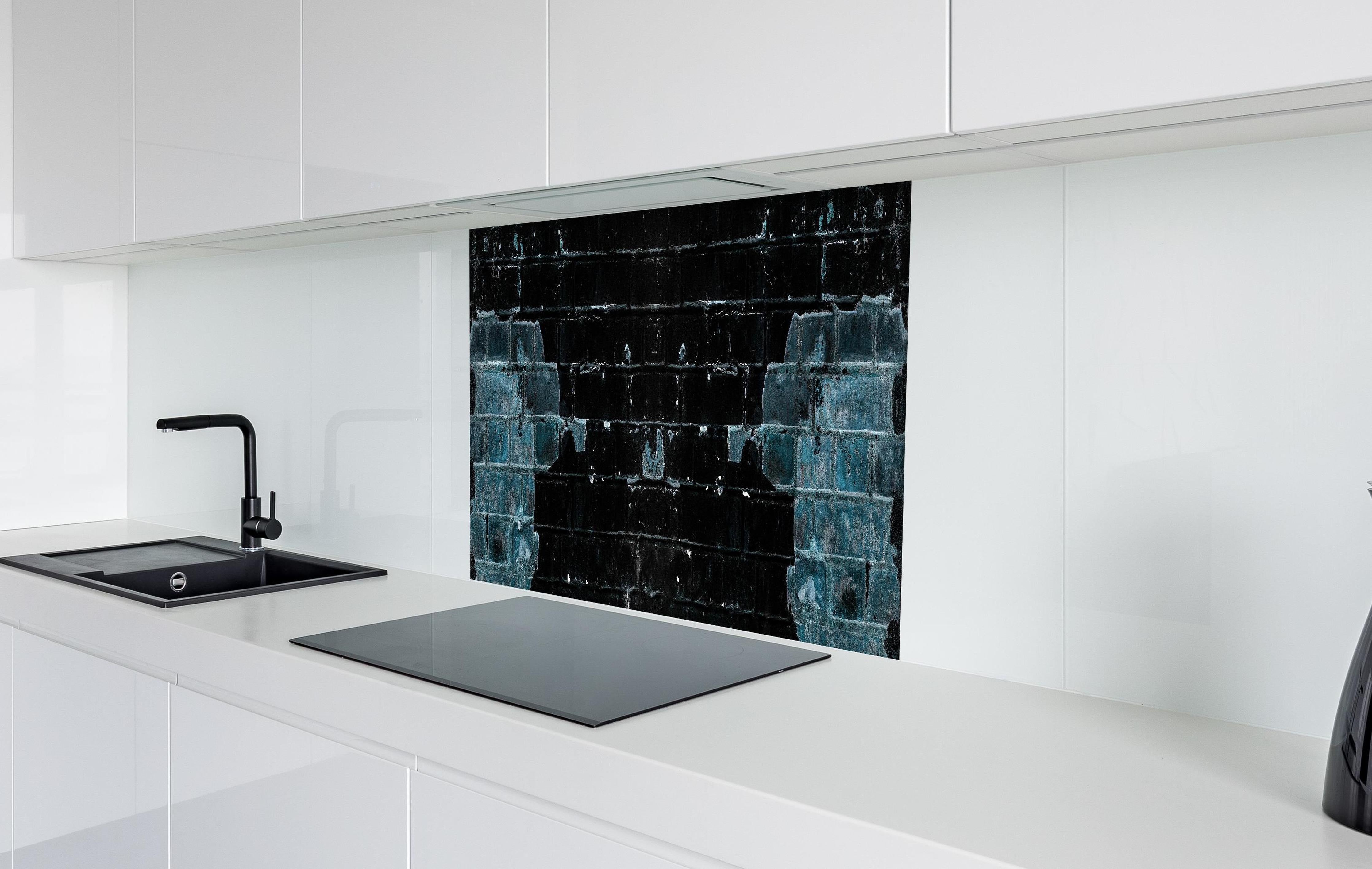 Spritzschutz - Blau schwarz beschädigte Ziegelwand hinter einem Cerankochfeld zwischen Holz-Kochutensilien