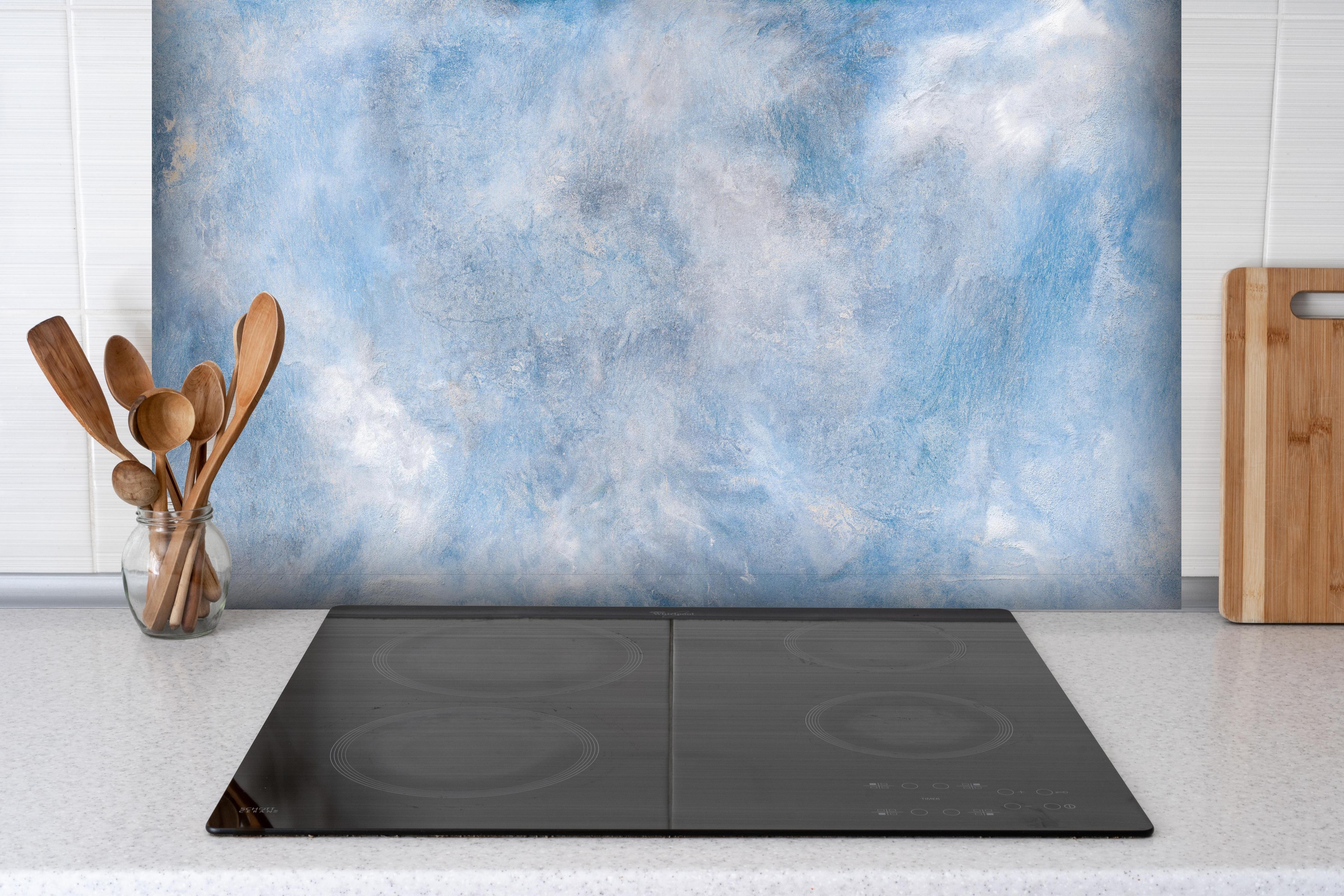 Spritzschutz - Blaue Marmor Textur hinter einem Cerankochfeld zwischen Holz-Kochutensilien