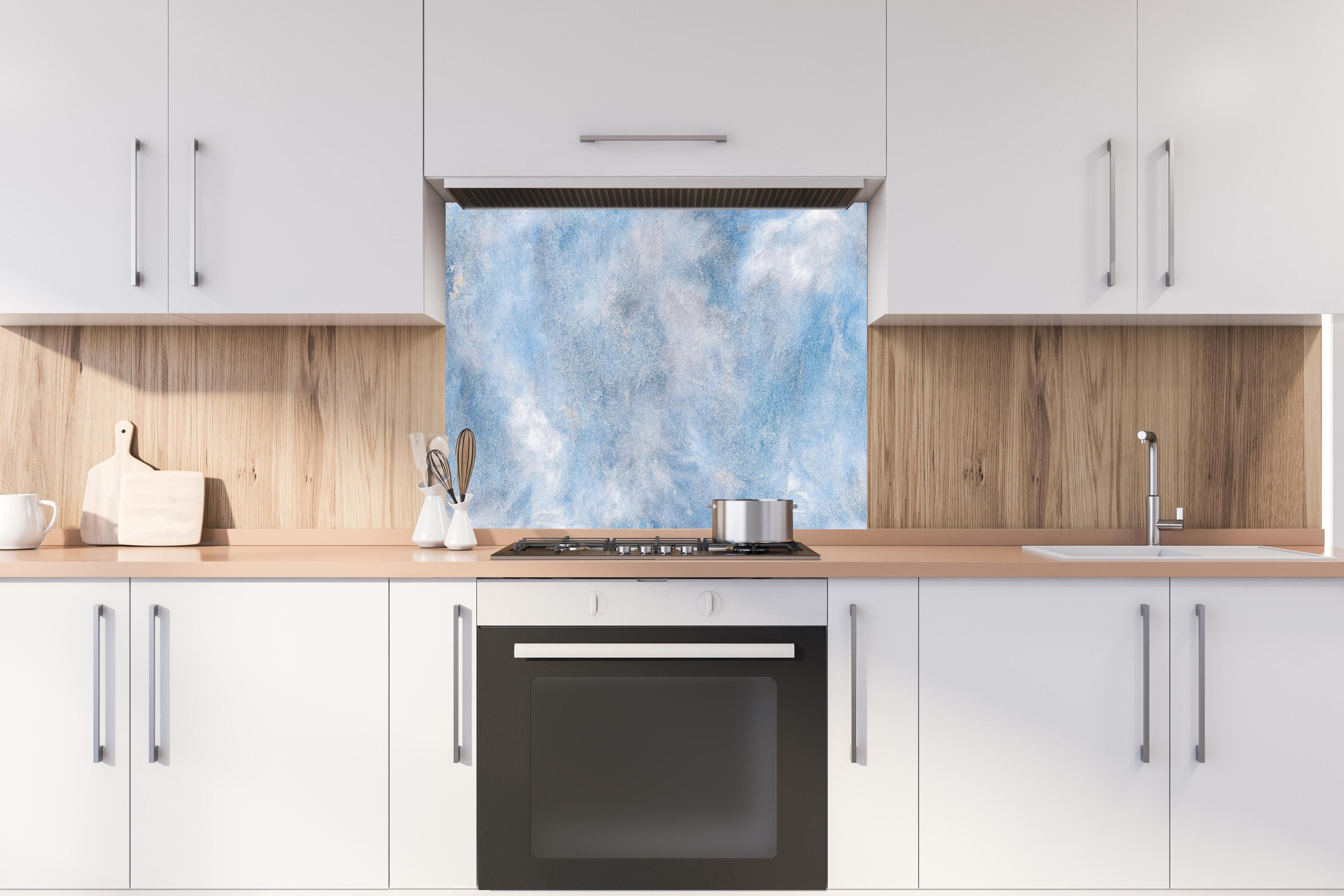 Spritzschutz - Blaue Marmor Textur hinter einem Cerankochfeld zwischen Holz-Kochutensilien