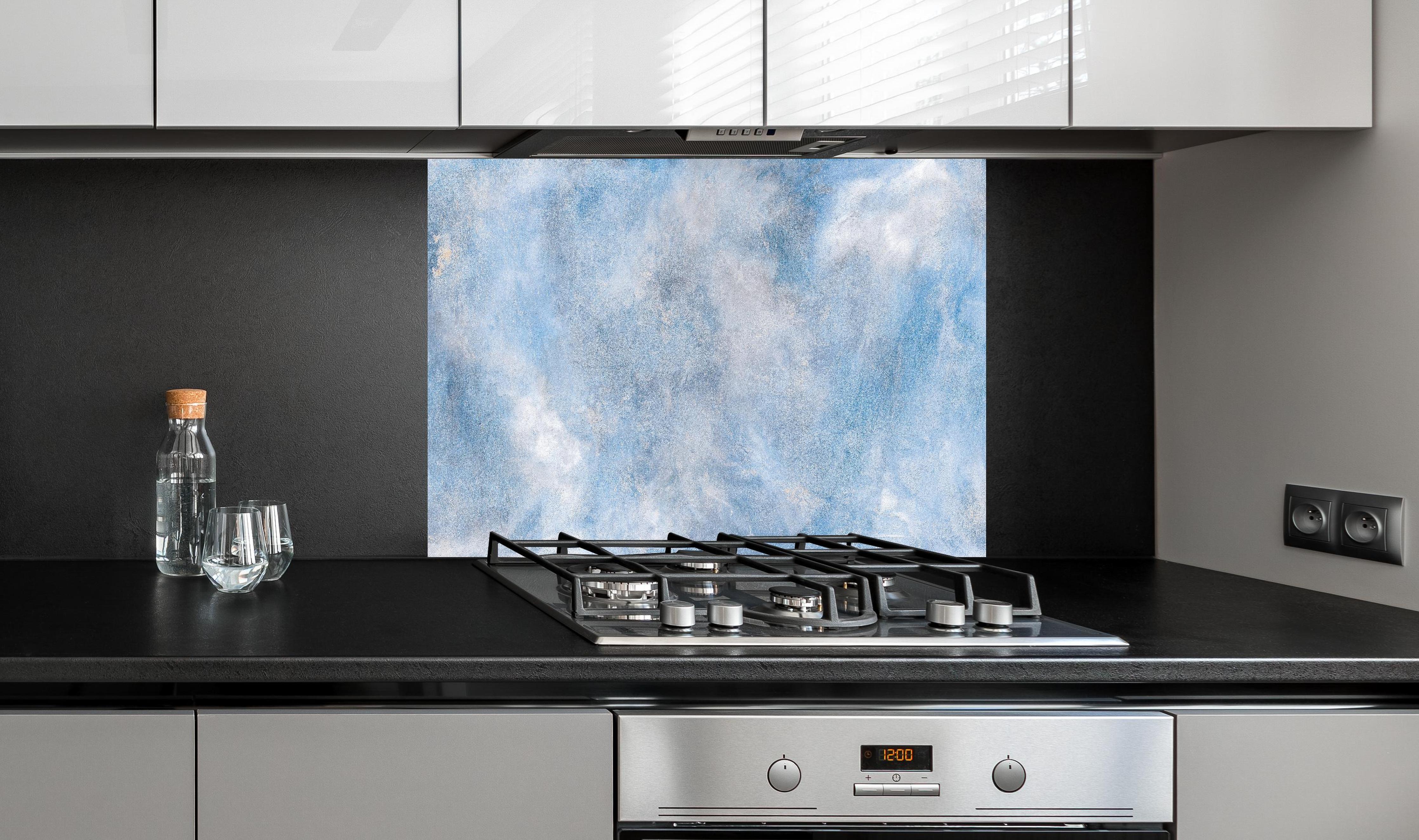 Spritzschutz - Blaue Marmor Textur hinter einem Cerankochfeld zwischen Holz-Kochutensilien