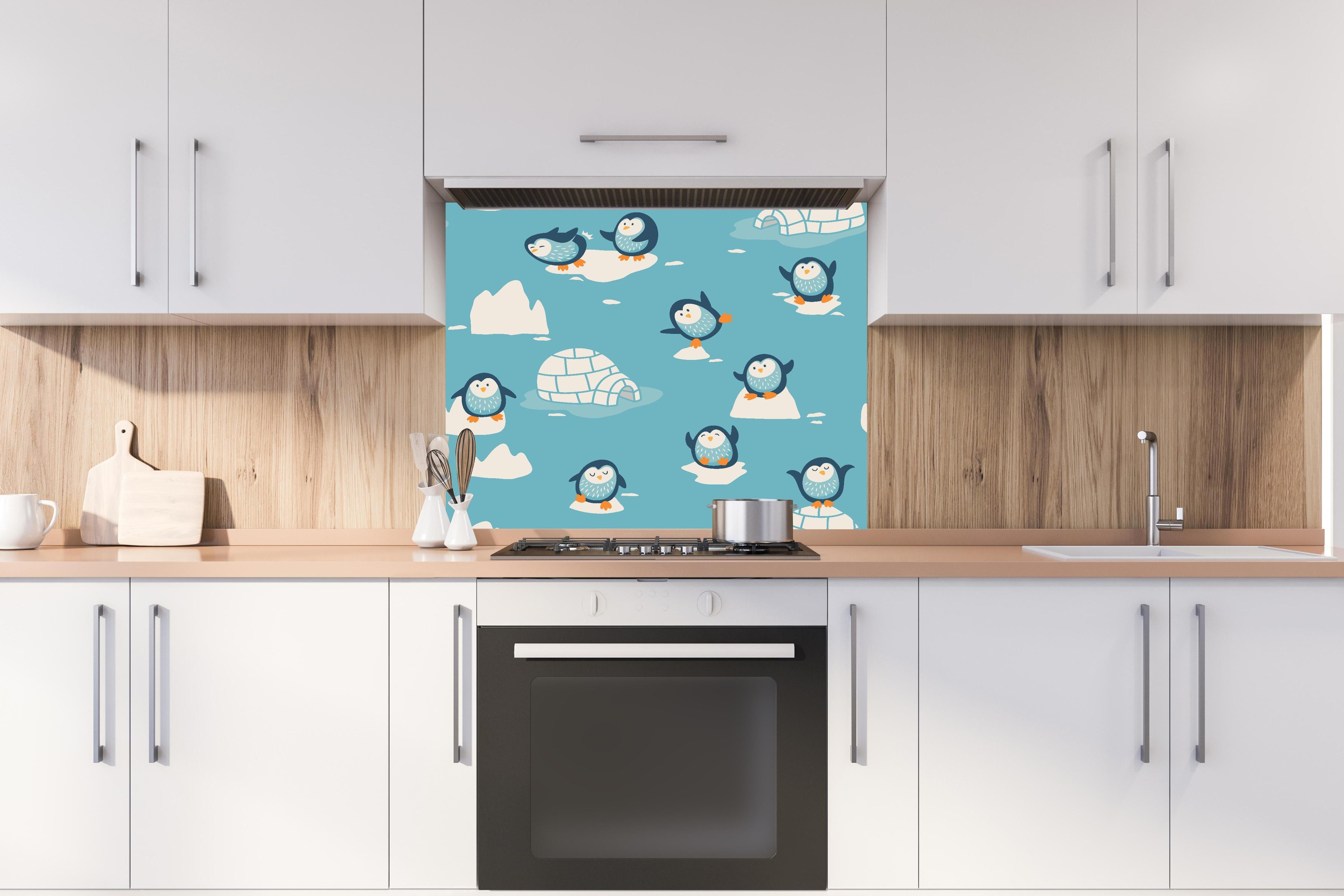 Spritzschutz - Blaue Pinguin Illustration Kindermuster hinter einem Cerankochfeld zwischen Holz-Kochutensilien
