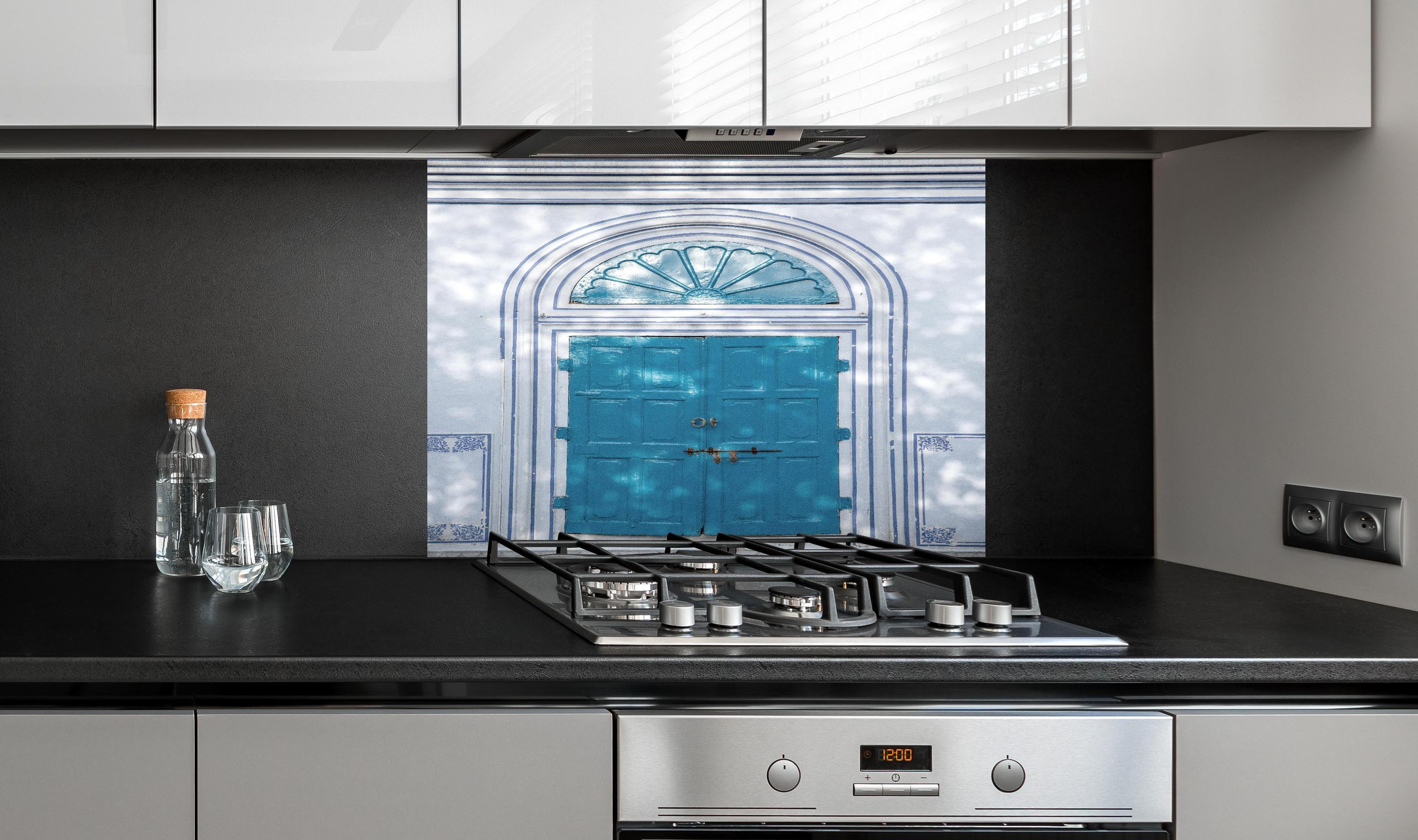 Spritzschutz - Blaue Tür - Architektur hinter einem Cerankochfeld zwischen Holz-Kochutensilien
