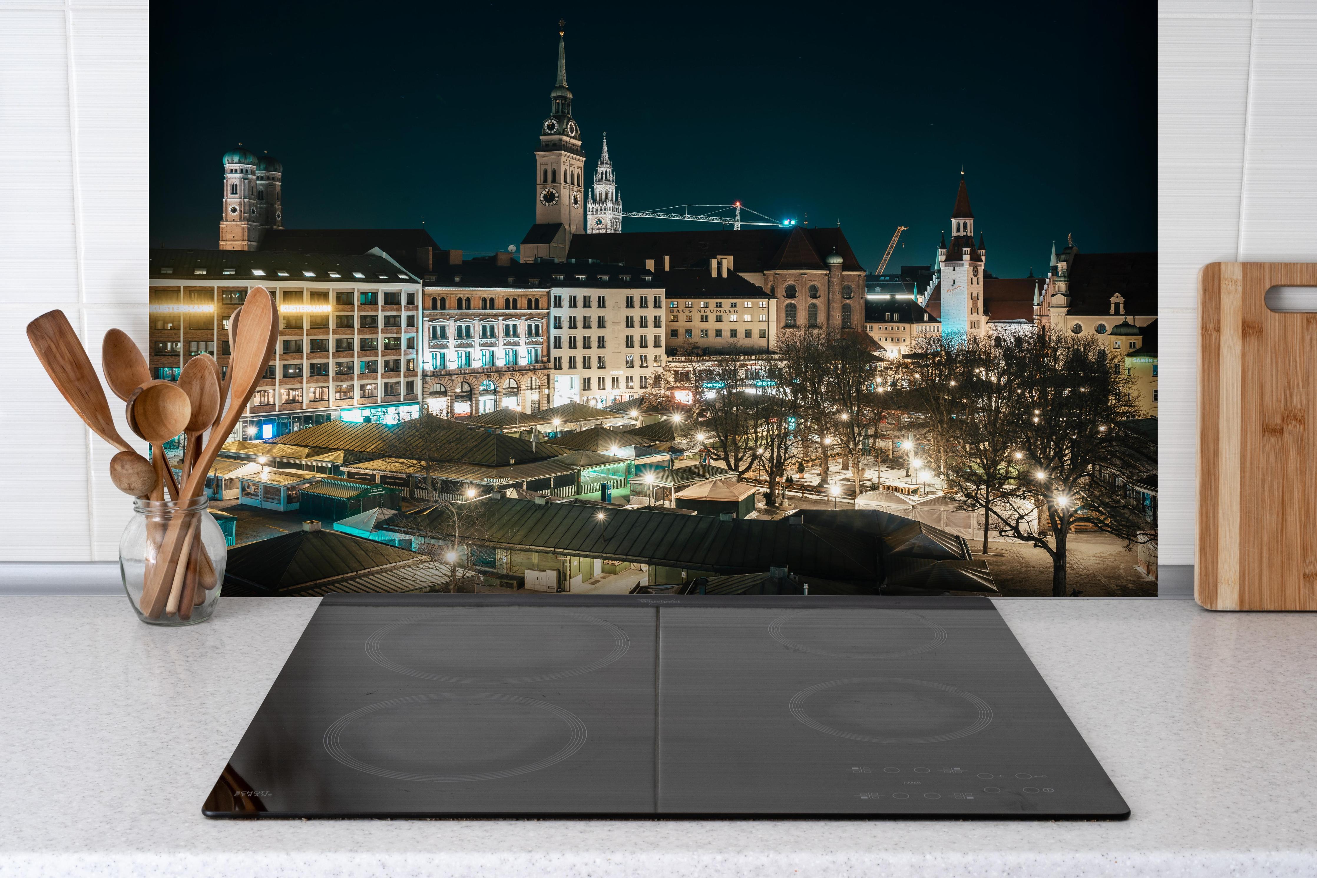 Spritzschutz - Blick über den Viktualienmarkt zur Frauenkirche - München hinter einem Cerankochfeld zwischen Holz-Kochutensilien