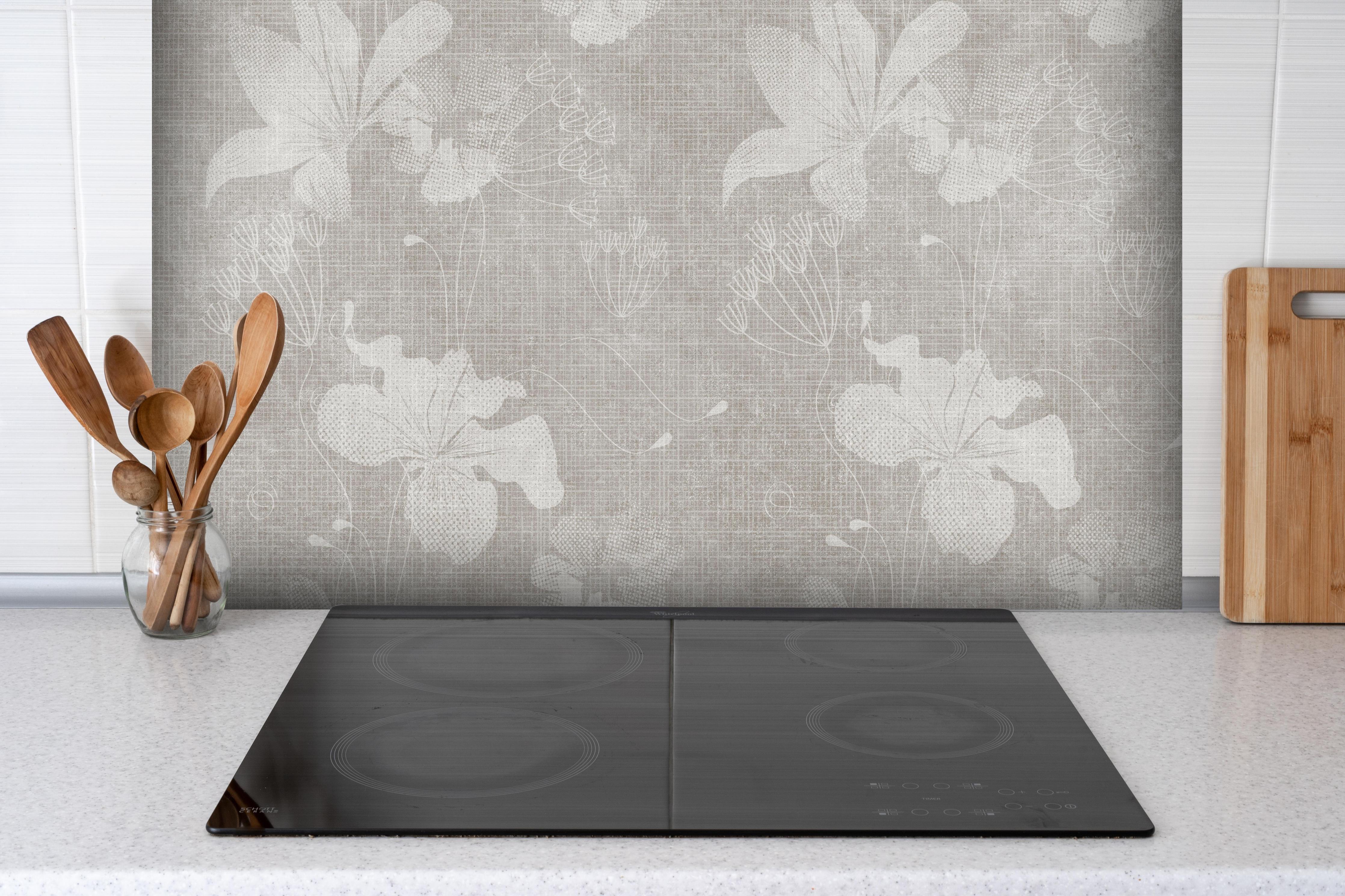 Spritzschutz - Blumen auf weißem Wandhintergrund hinter einem Cerankochfeld zwischen Holz-Kochutensilien